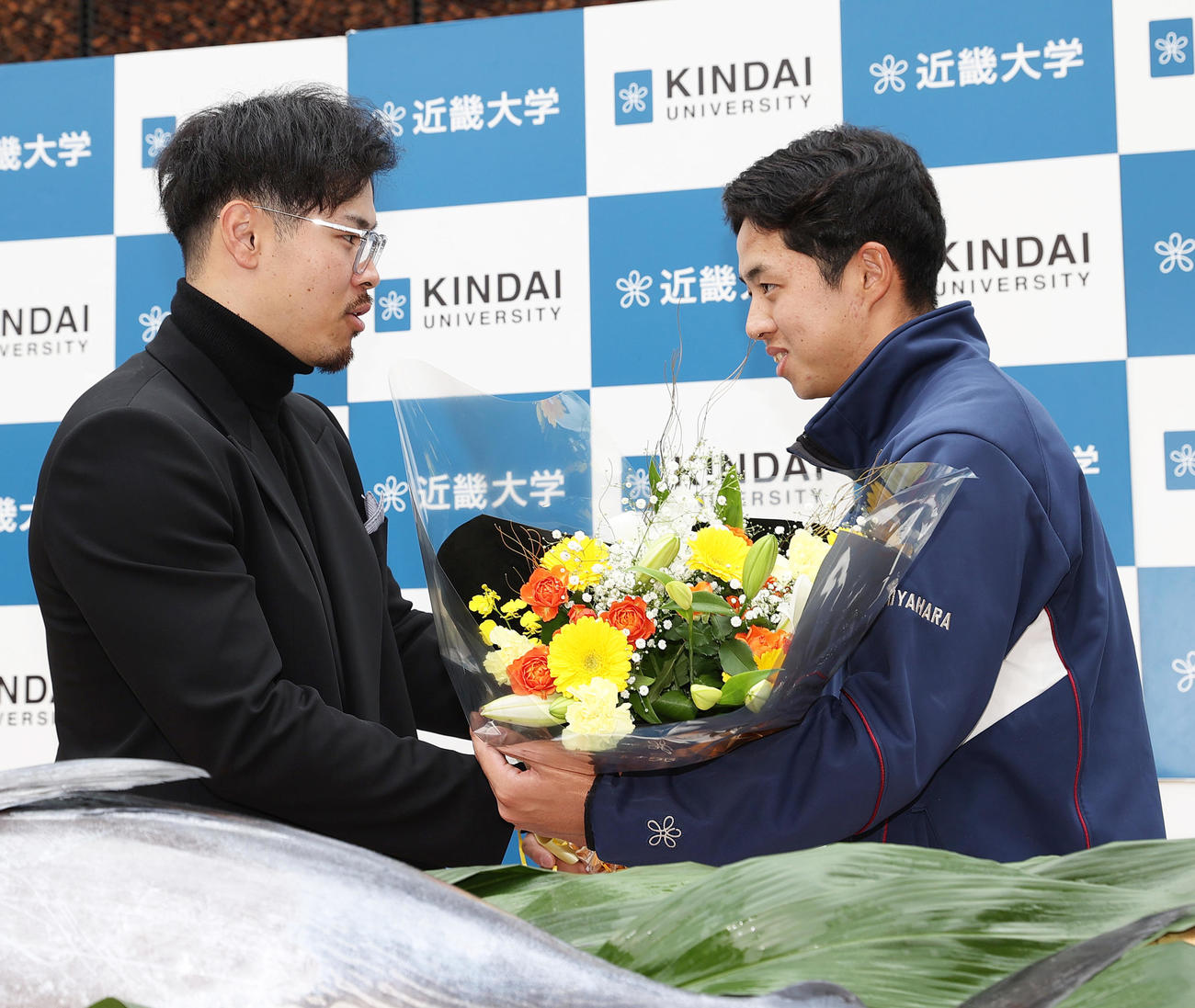 近大後輩の宮原さん（右）から花束を受け取る阪神佐藤輝（撮影・上山淳一）