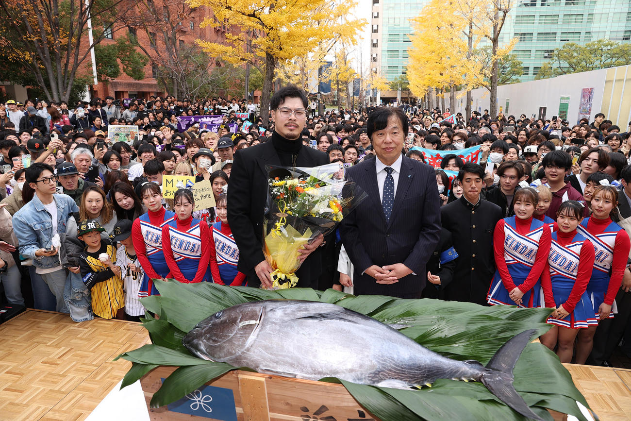 近大マグロが贈られ記念撮影する阪神佐藤輝。右は近大の松村学長（撮影・上山淳一）