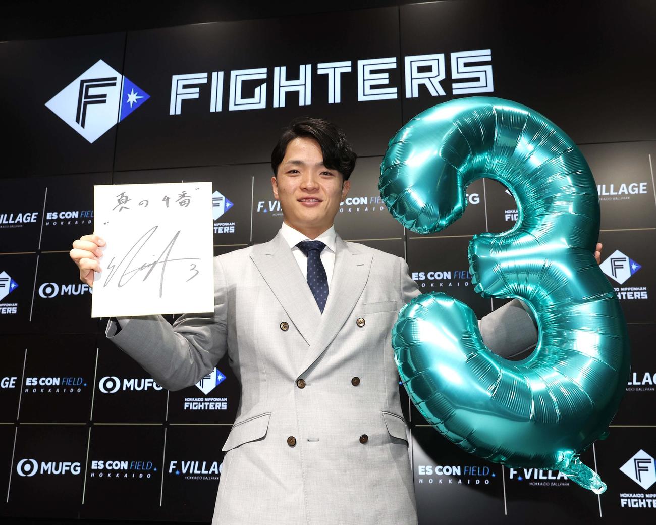 契約更改後、新背番号「3」を掲げ笑顔の郡司（撮影・黒川智章）