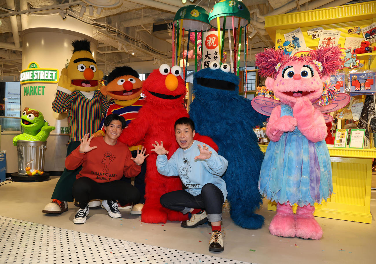 阪神梅田本店にセサミストリートマーケットがオープンし記念セレモニーでキャラクターたちと写真に納まる阪神湯浅（左）とますだおかだ増田。後列左からバート、アーニー、エルモ、クッキーモンスター、アビー（撮影・加藤哉）
