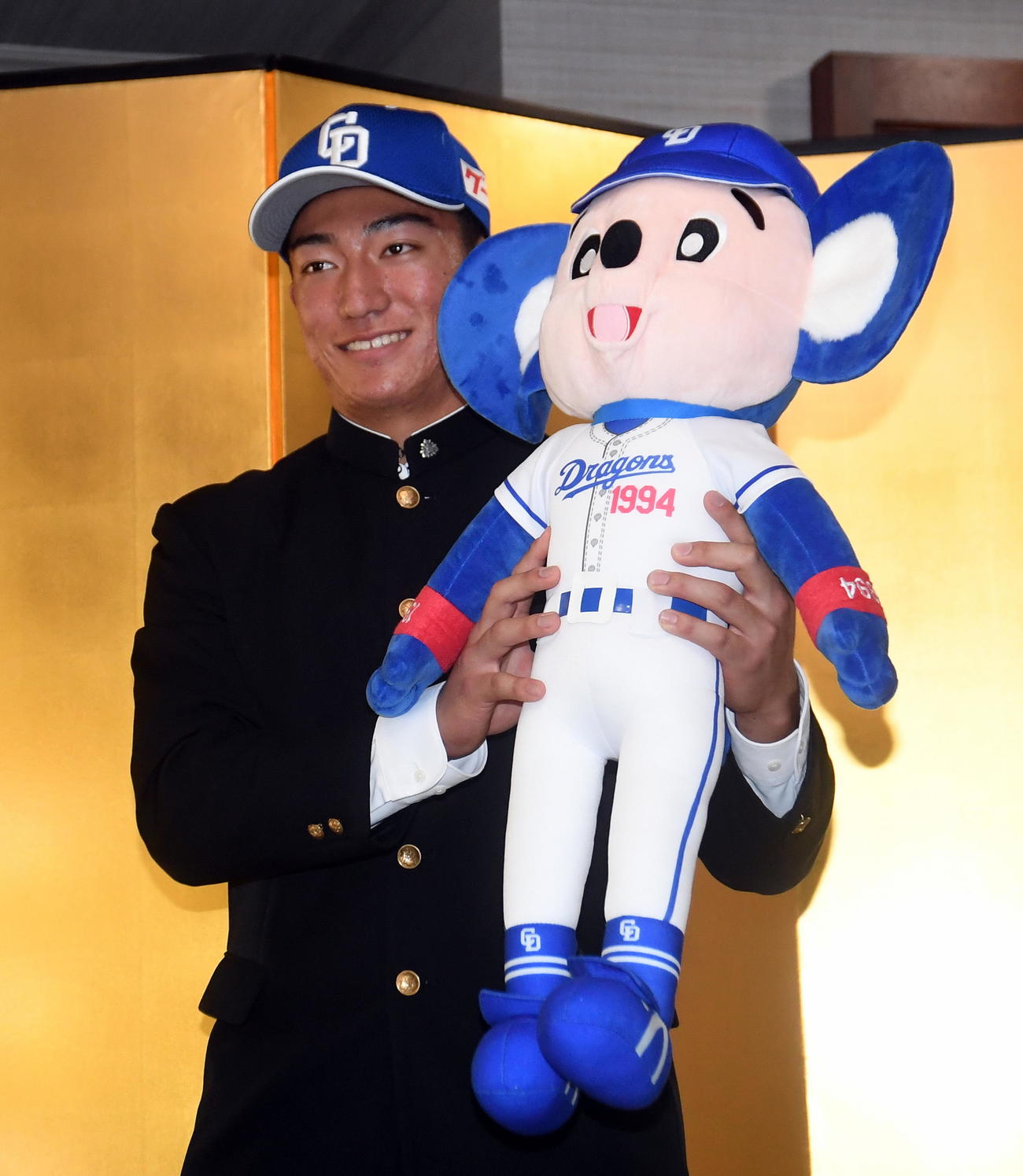 球団から贈られたドアラ人形を手に笑顔を見せる中日育成2位の掛川西・石川