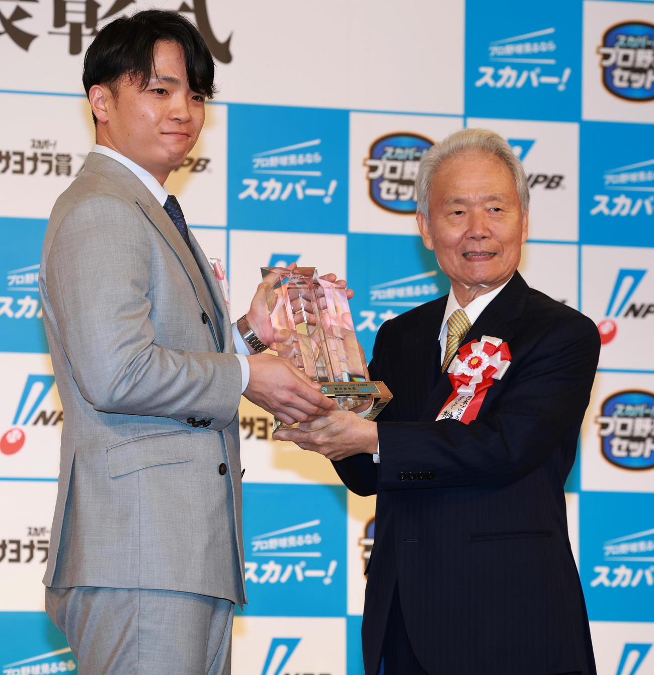「2025　スカパー！ドラマティック・サヨナラ賞　年間大賞」を受賞し、NPB榊原コミッショナー（右）から表彰されるパ・リーグの日本ハム郡司（撮影・野上伸悟）
