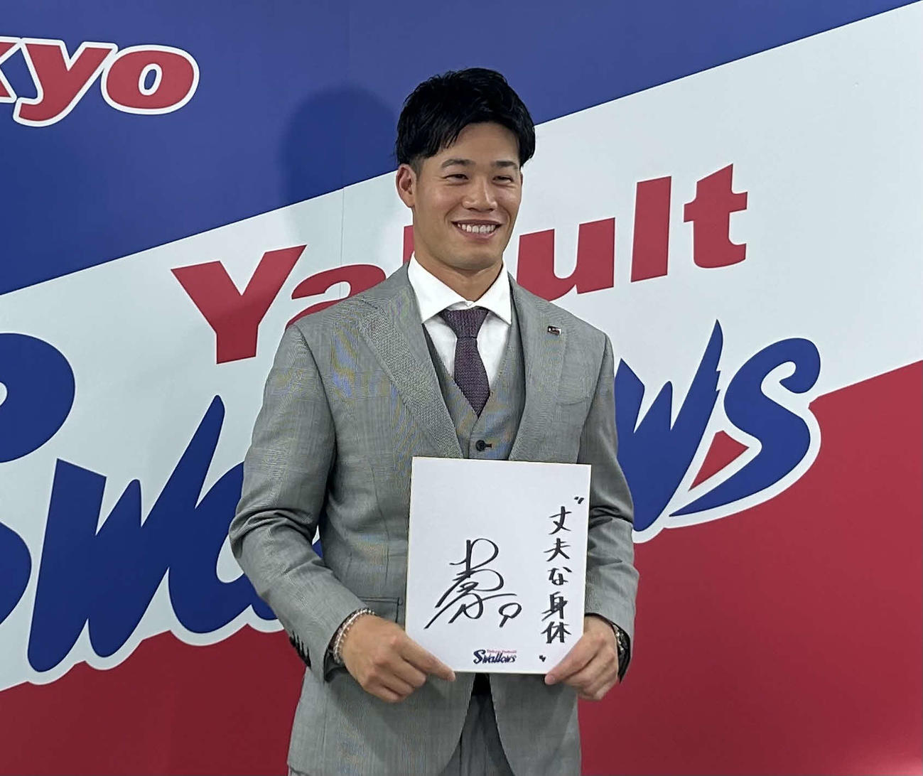 都内の球団事務所で契約更改に臨み来季目標「“丈夫な体”」を色紙に記し笑顔で写真に納まるヤクルト塩見