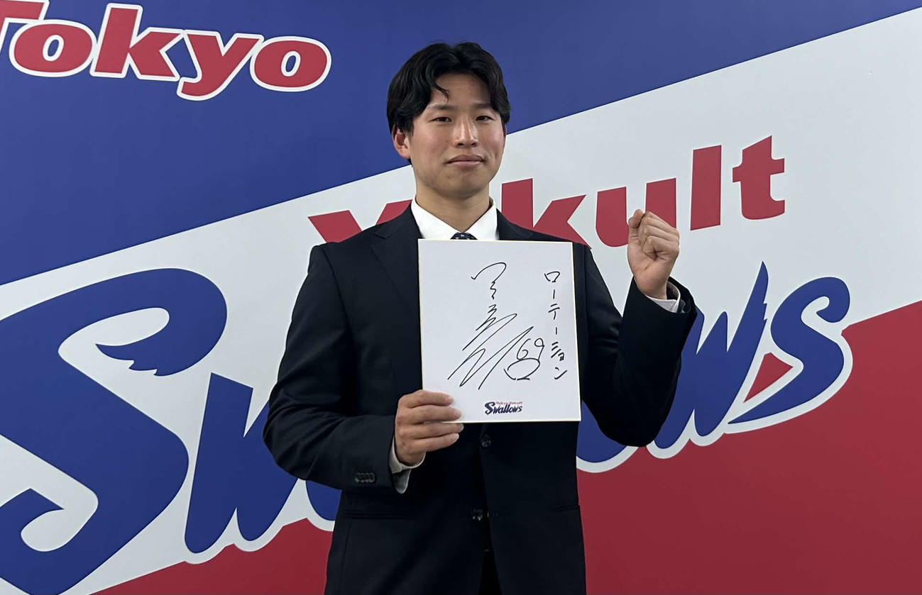 都内の球団事務所で契約更改に臨み来季目標「ローテーション」を記した色紙を掲げて笑顔を見せるヤクルト下川