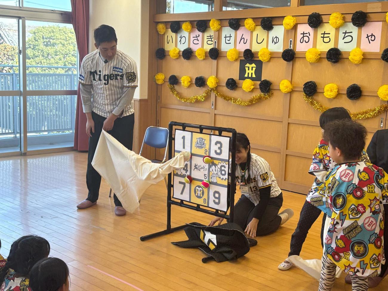 阪神岩崎（左）と園児が幕を引っ張って寄贈したストラックアウトがお披露目となった（撮影・塚本光）