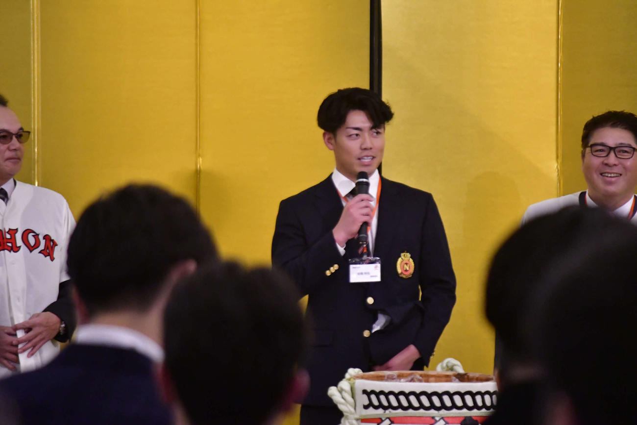 マイクを持って壇上で話す阪神2位の谷端（撮影・平山連）