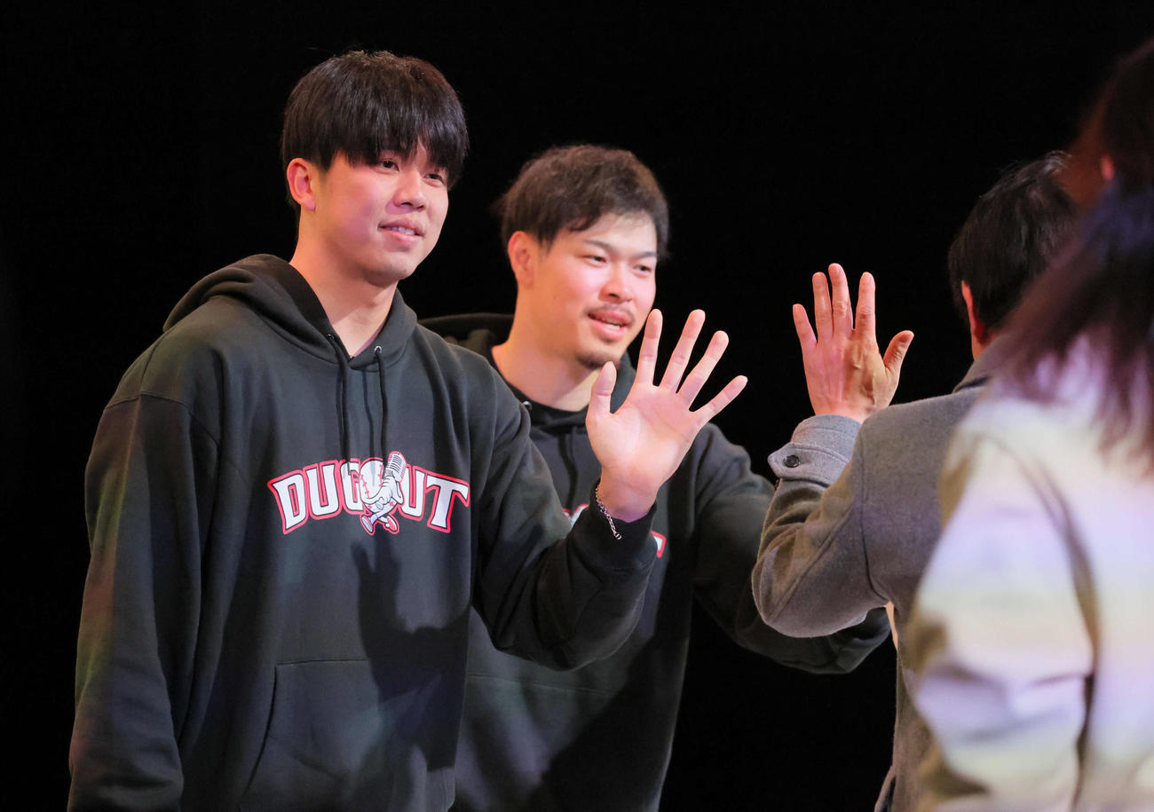 ダグアウトトークショーでハイタッチする才木（左）と佐藤輝（撮影・宮崎幸一)