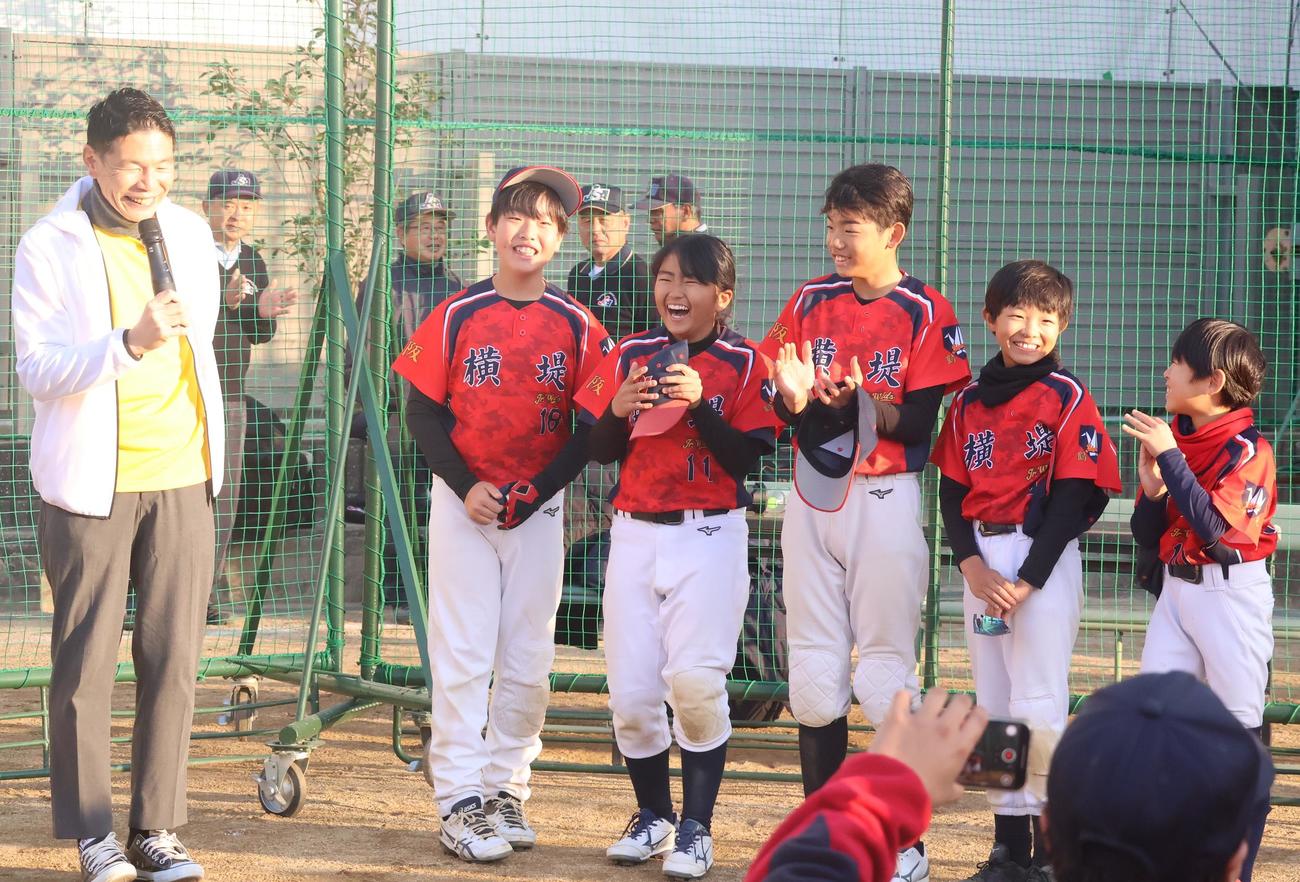 第1回今岡真訪杯で優勝し、サンテレビ湯浅アナウンサー（左端）からインタビューを受ける横堤ジュニアワイルズの選手たち（撮影・塚本光）