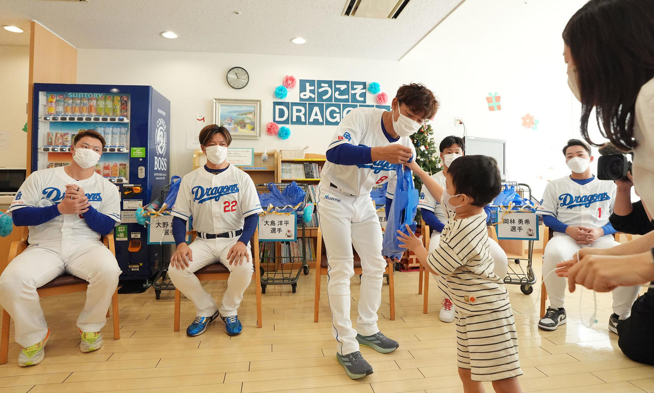 大島（中央）はイベント後に病棟を訪れ子どもたちにプレゼントを渡す（撮影・森本幸一）