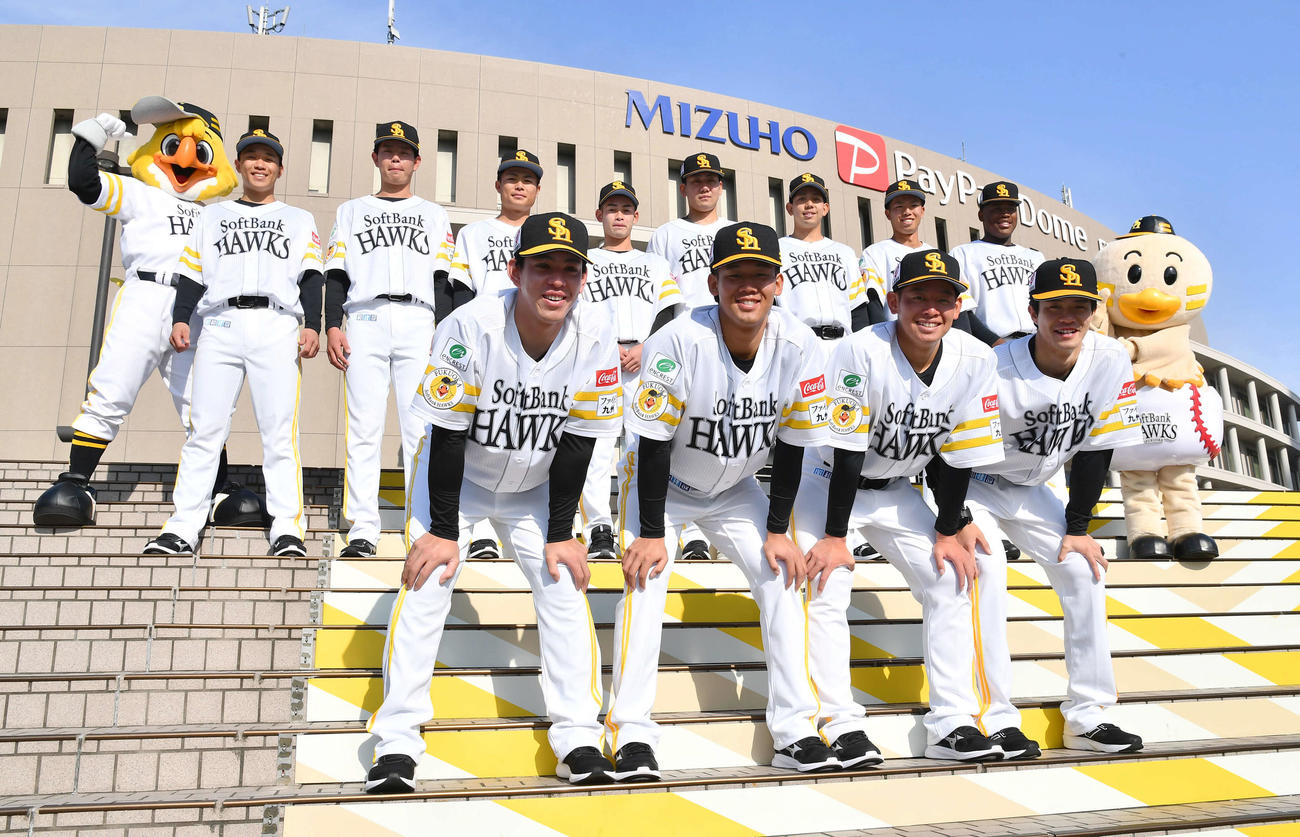 本拠地みずほペイペイドームを背に集合写真に納まる、前列左からソフトバンクドラフト5位・高橋、2位・稲川、3位・鈴木豪、4位・相良、後列左から育成8位・大山北、育成6位・長崎、育成4位大橋、育成2位・江崎、育成1位・池田、育成3位・大矢、育成5位・鈴木貴、育成7位・エミール（撮影・岩下翔太）