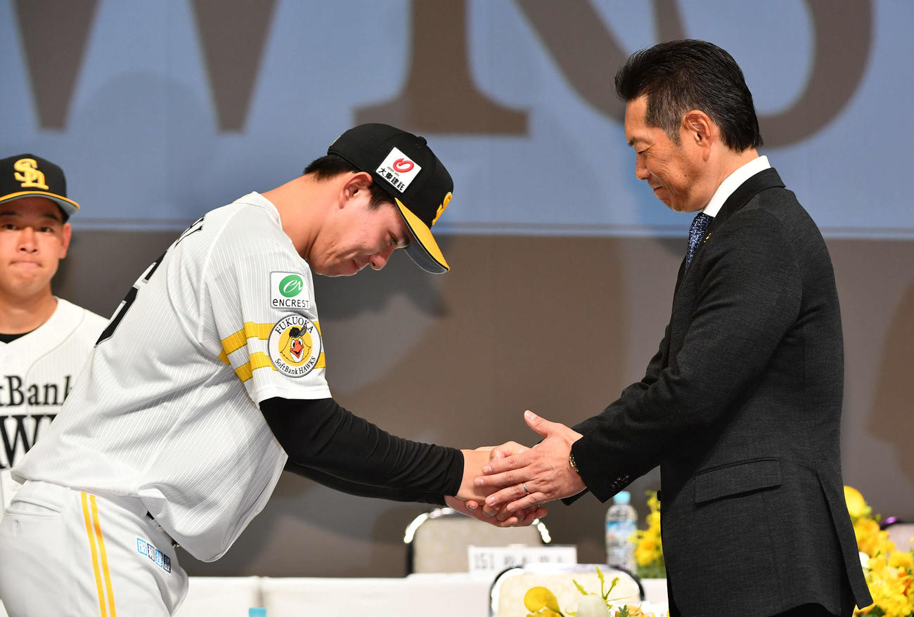ソフトバンク新入団選手発表会見でドラフト5位の高橋（左）と握手を交わす小久保監督（撮影・岩下翔太）