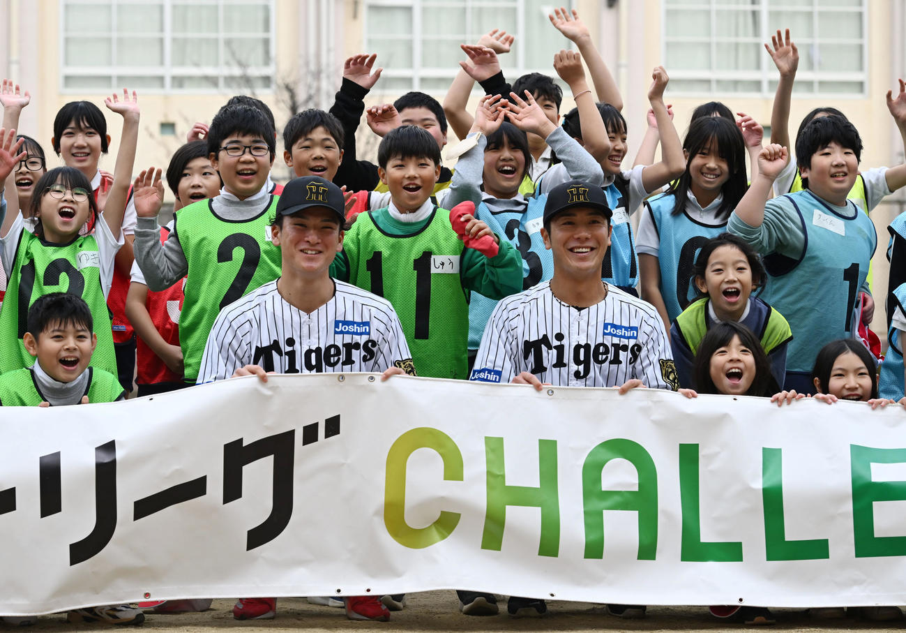 将来、地域の未来を支える小学生と記念撮影する阪神高寺（手前左）と豊田（撮影・和賀正仁）