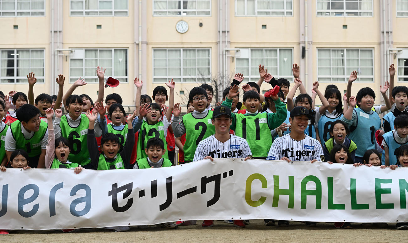 将来、地域の未来を支える小学生と記念撮影する阪神高寺（手前左）と豊田（撮影・和賀正仁）