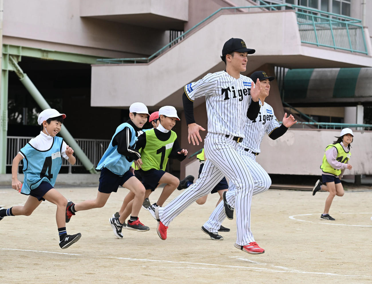 スポーツが与える感動についての授業で小学生とランニングする阪神高寺（手前）と豊田（撮影・和賀正仁）