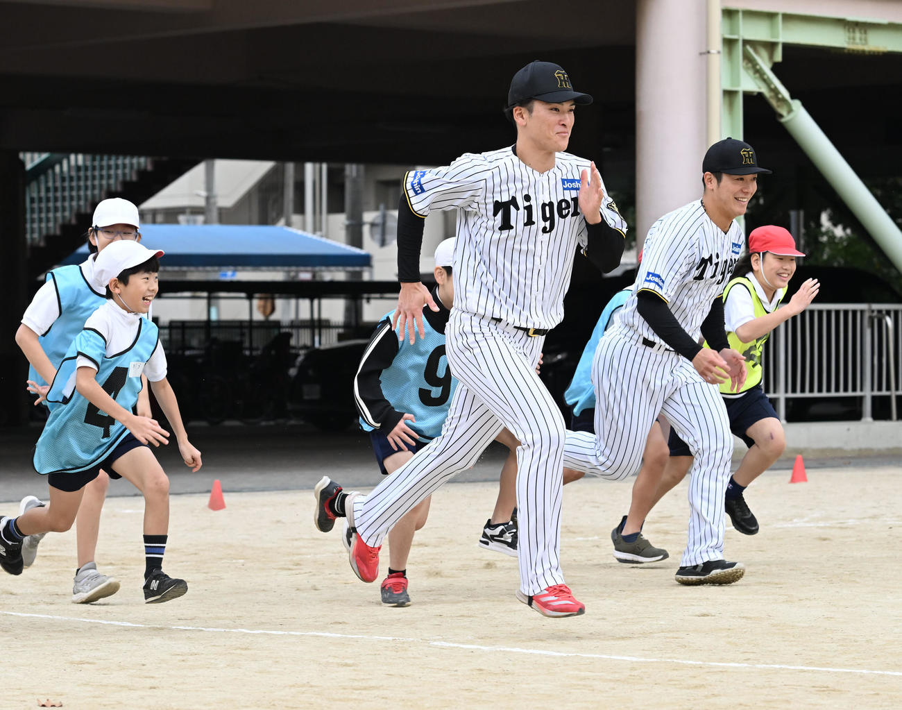 スポーツが与える感動についての授業で小学生とランニングする阪神高寺（手前）と豊田（撮影・和賀正仁）