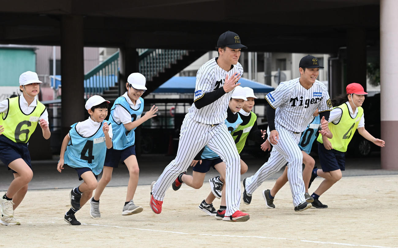 スポーツが与える感動についての授業で小学生とランニングする阪神高寺（手前）と豊田（撮影・和賀正仁）