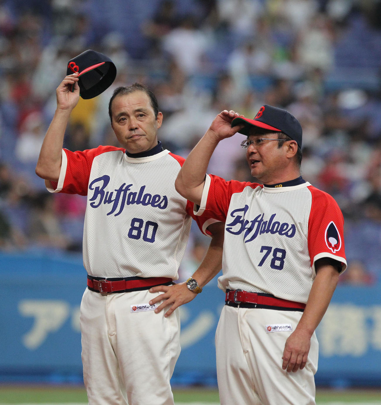 ロッテに勝ち帽子を取ってファンにあいさつする岡田監督。右は高代コーチ（2011年8月28日撮影）