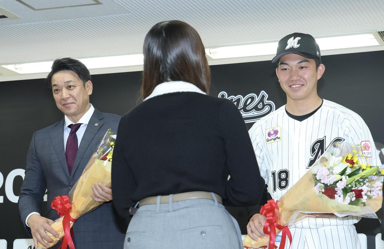 ロッテ新入団選手発表会で花束を受け取るサブロー監督（左）と石垣（撮影・河田真司）