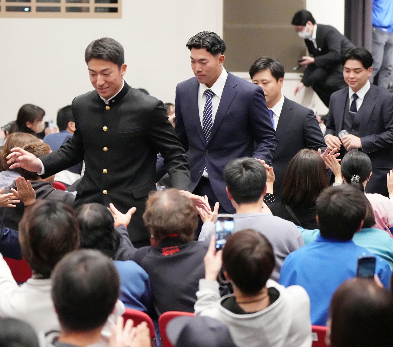 歓迎会を終えファンとタッチを交わしながら退場する奥・左から石川大、篠崎、牧野、中西（撮影・森本幸一）