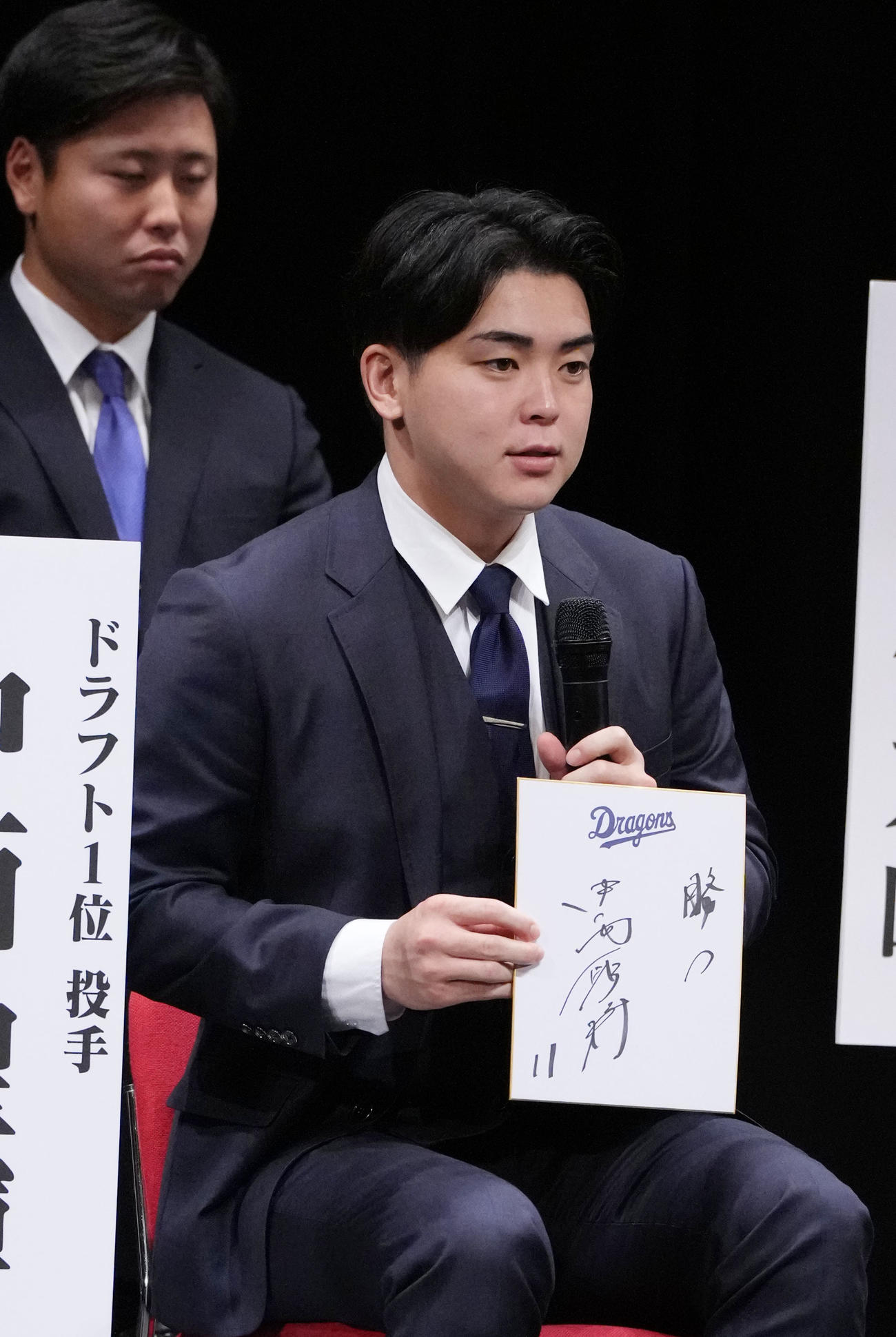 中西（右）は色紙に目標を「勝つ」と記し披露する（撮影・森本幸一）