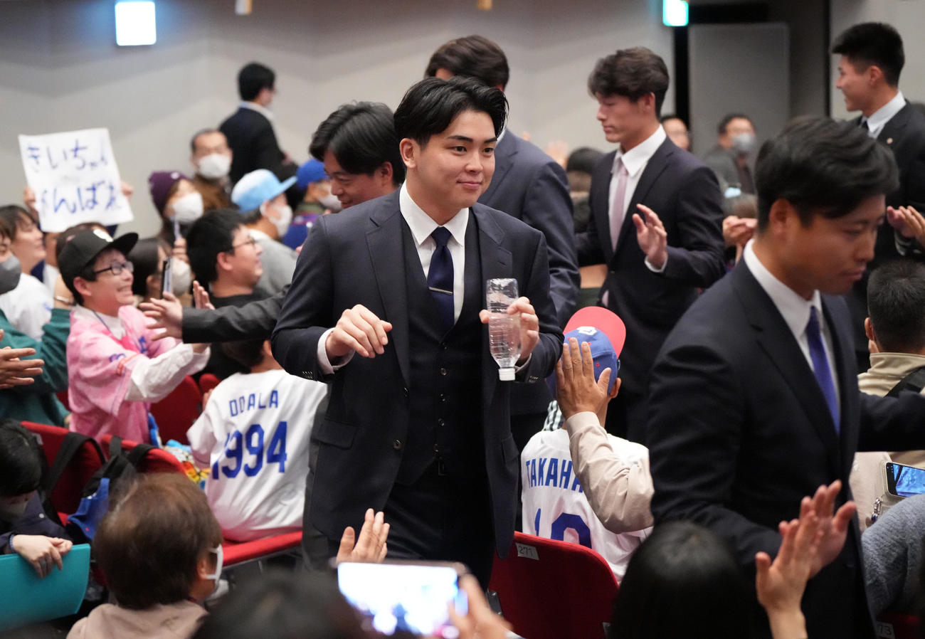 中西（中央）は歓迎会を終えファンとタッチを交わしながら退場する（撮影・森本幸一）