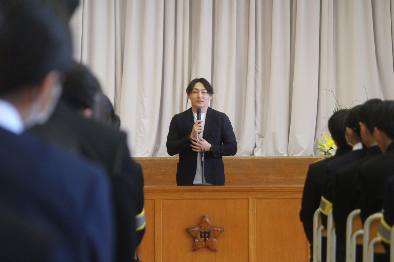 中学生を前に講演する丸