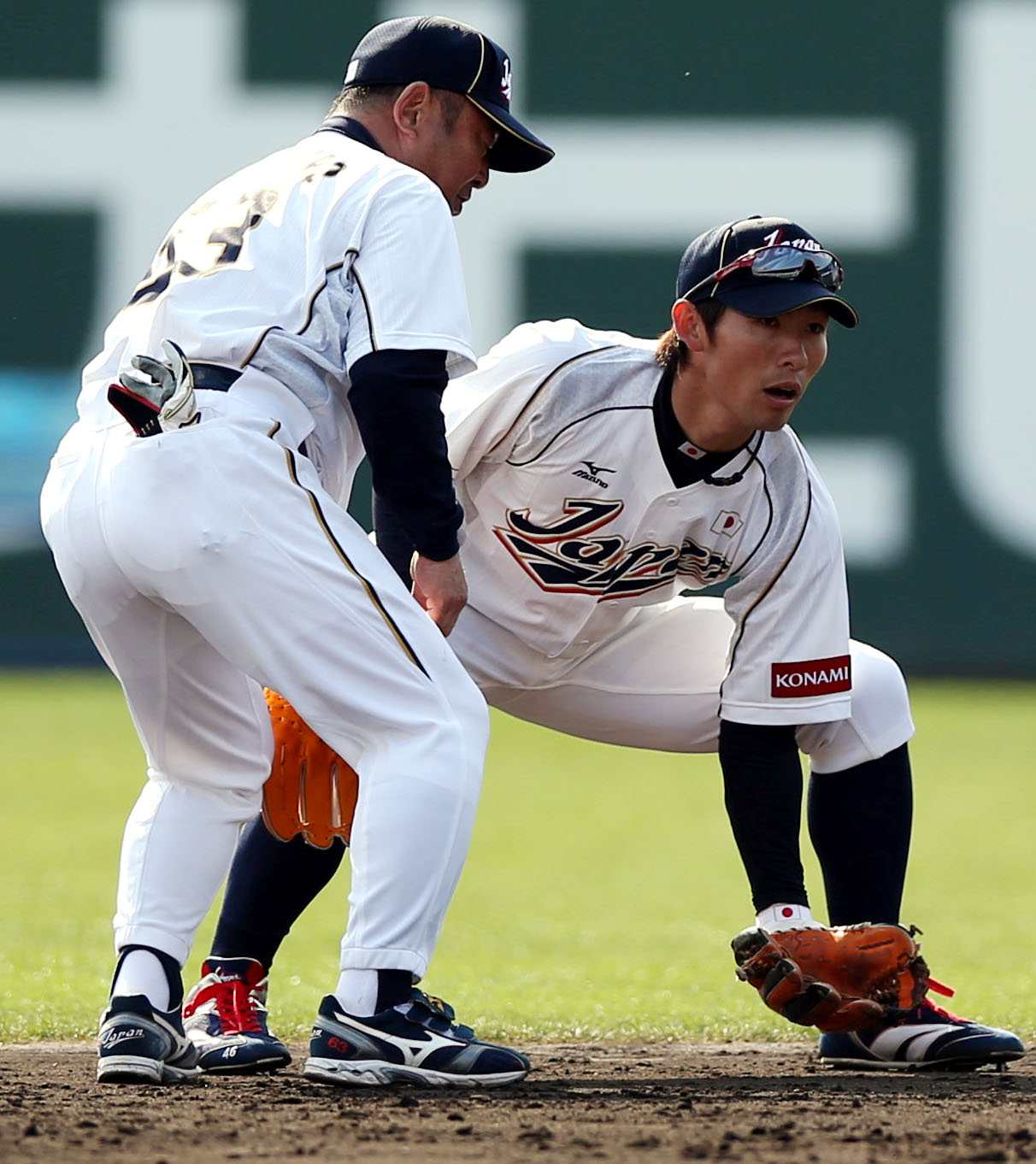 高代コーチ（左）から捕球の姿勢の指導を受ける本多雄一（2013年2月15日撮影）