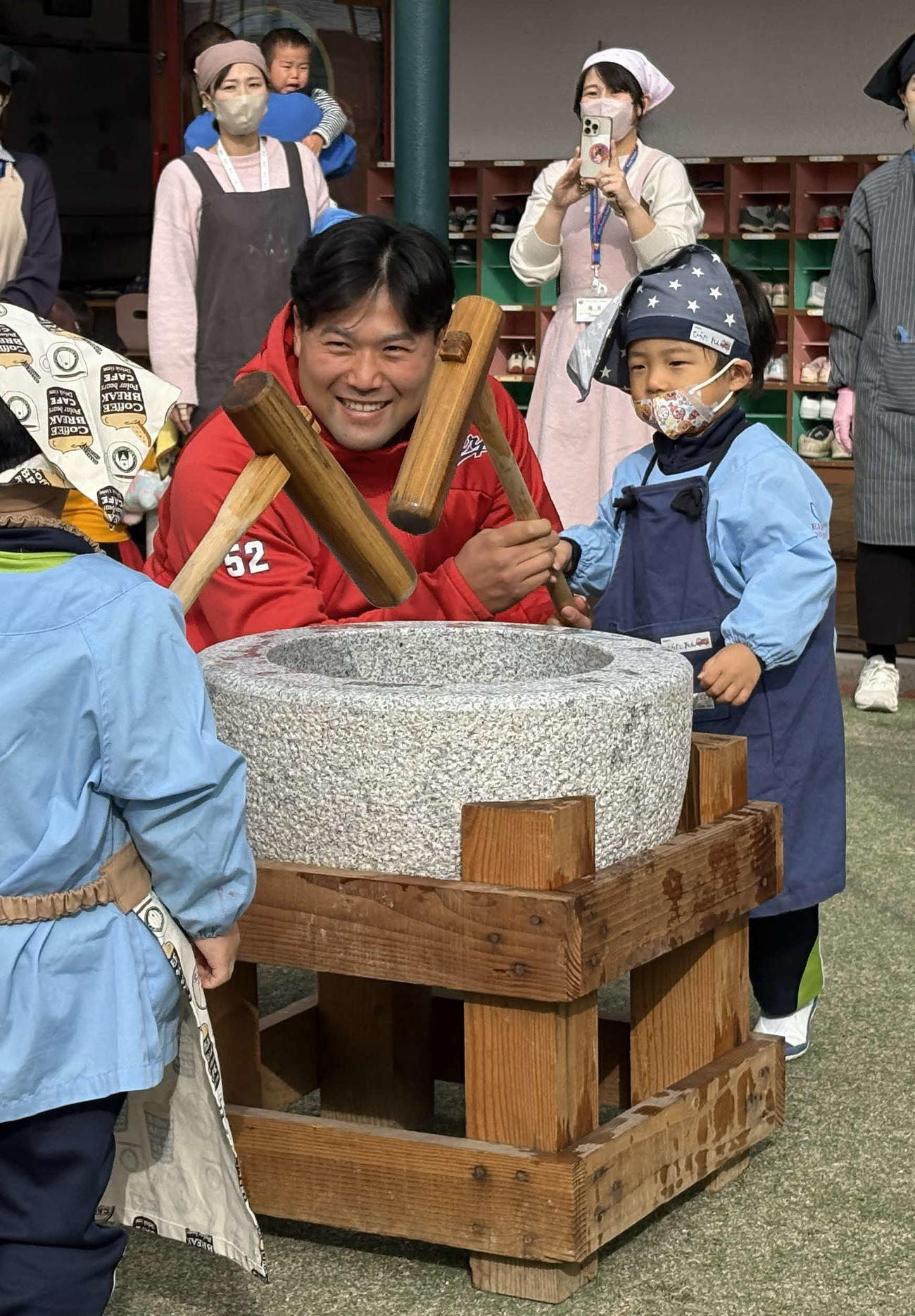 園児と一緒に餅をつく広島末包昇大外野手（撮影・前原淳）