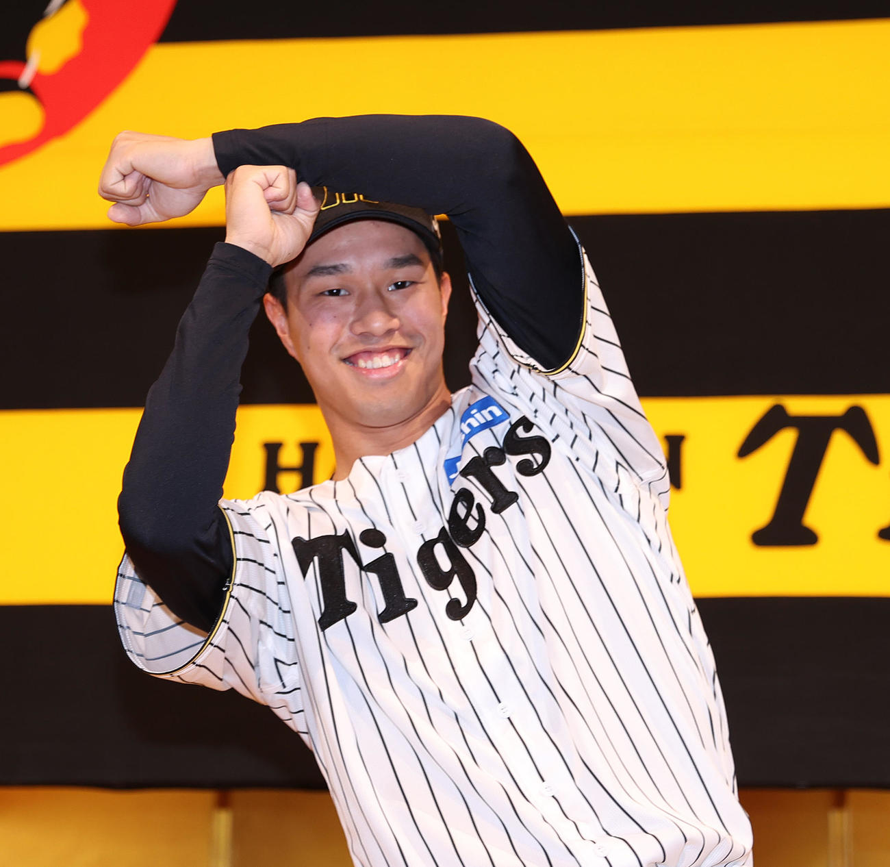 阪神新人入団会見でポーズをとるドラフト3位の岡城（撮影・上山淳一）