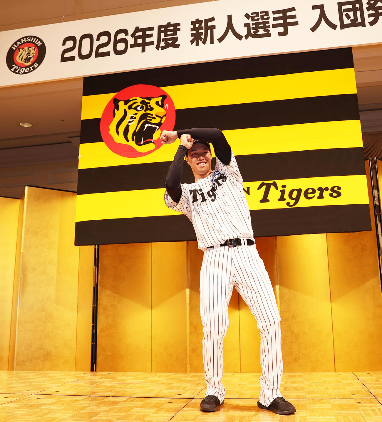 阪神新人入団会見でポーズをとるドラフト3位の岡城（撮影・上山淳一）