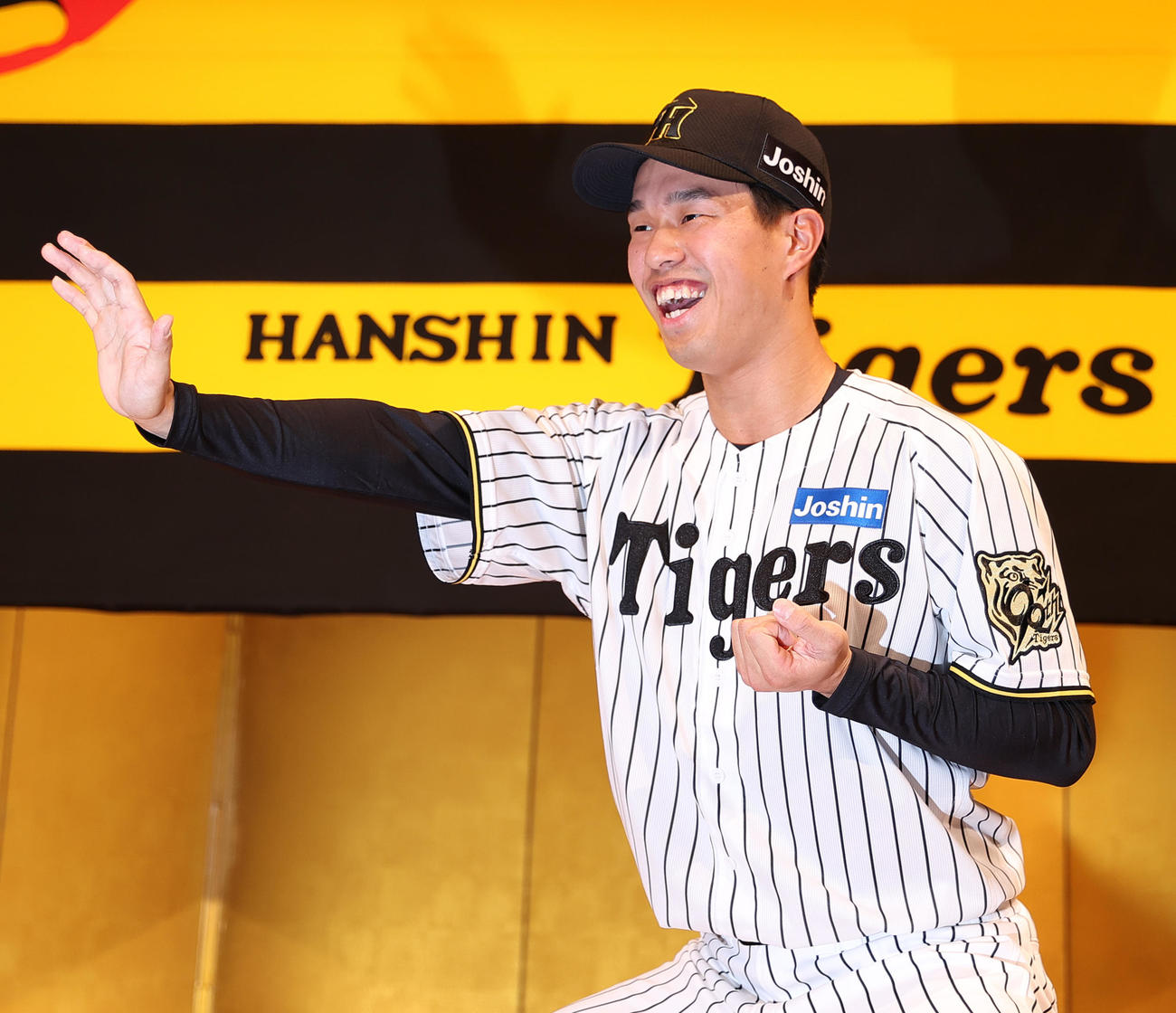 阪神新人入団会見でポーズをとるドラフト3位の岡城（撮影・上山淳一）