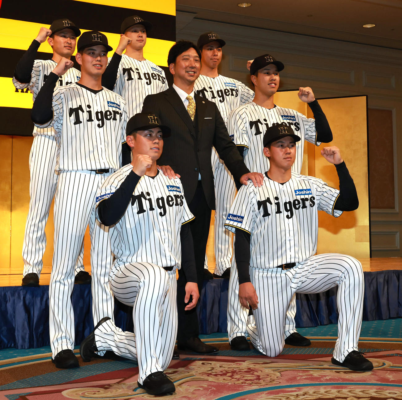 藤川監督（中央）と写真に収まる下段左からドラフト2巡目谷端、1巡目立石、中段左から4巡目早瀬、一人置いて3巡目岡城、上段左から育成2巡目山崎、5巡目能登、育成1巡目神宮（撮影・上田博志）