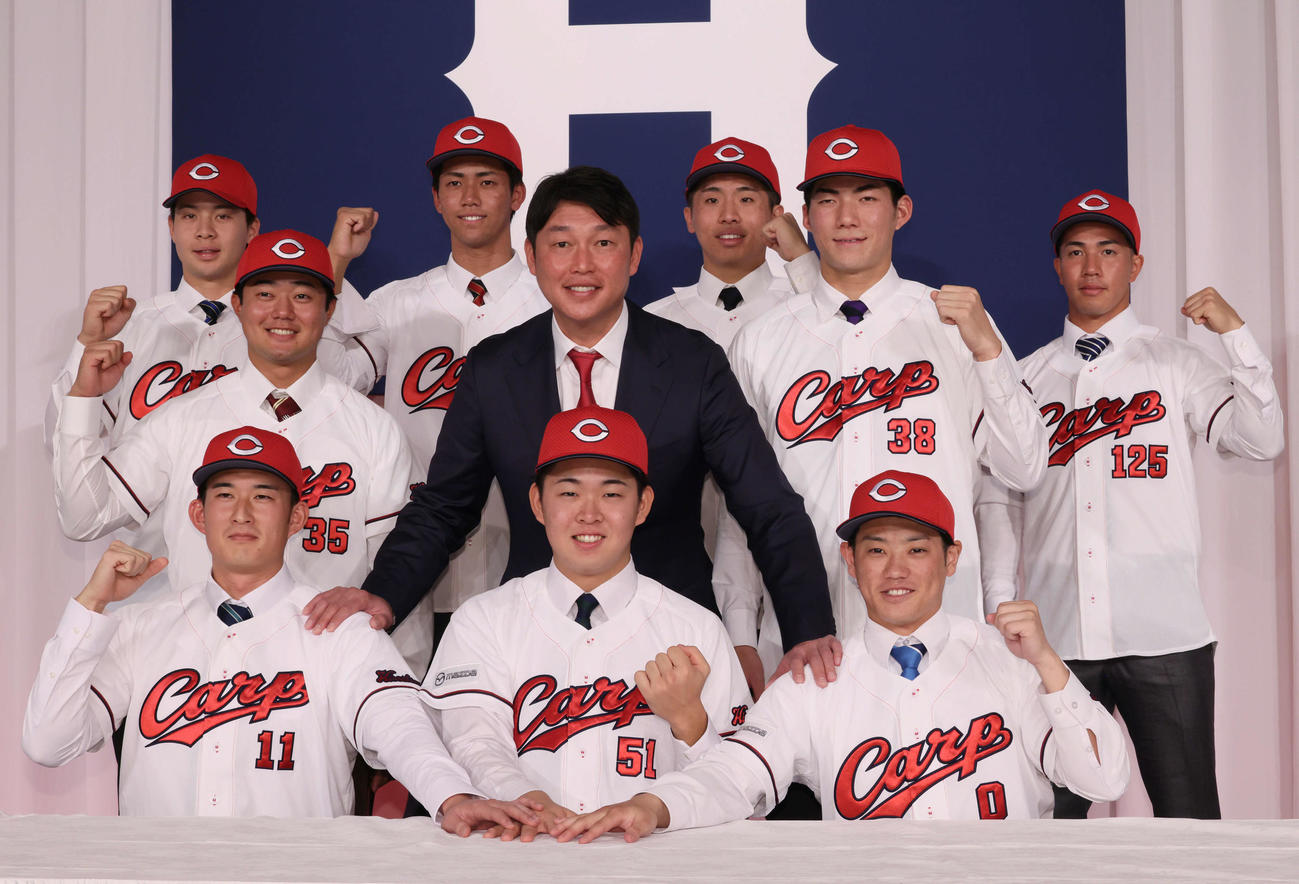 新井監督を中心に入団会見で写真に納まる広島の、前列左からドラフト2位の斉藤汰直、1位の平川蓮、3位の勝田成、中列左から4位の工藤泰己、1人おいて5位の赤木晴哉、後列左から育成1位の小林結太、6位の西川篤夢、7位の高木快大、育成2位の岸本大希（撮影・加藤孝規）