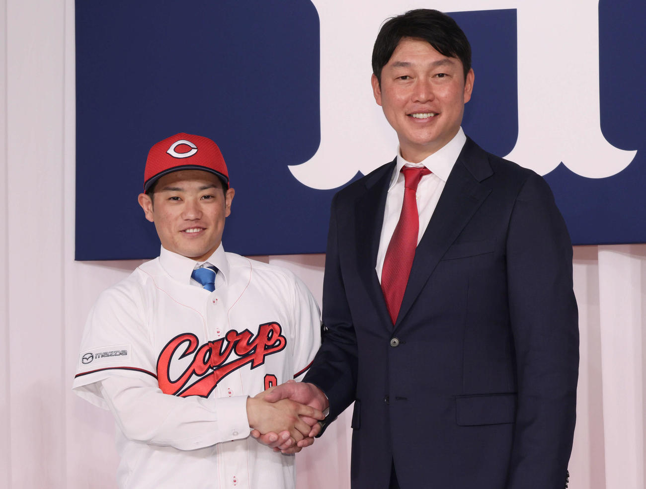 新井監督（右）と握手するドラフト3位の勝田（撮影・加藤孝規）