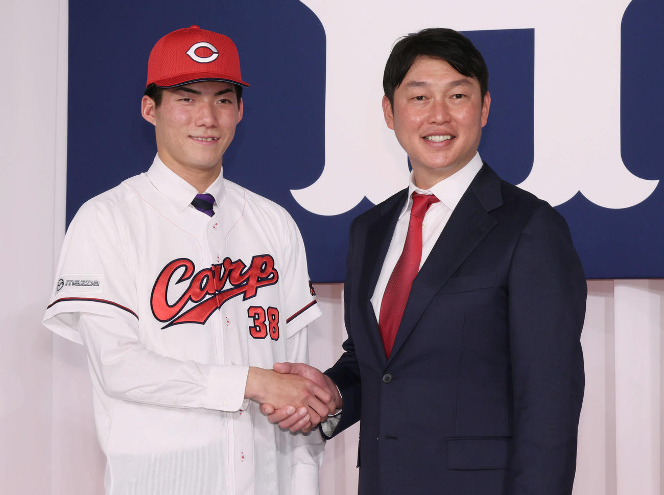 新井監督（右）と握手するドラフト5位の赤木（撮影・加藤孝規）