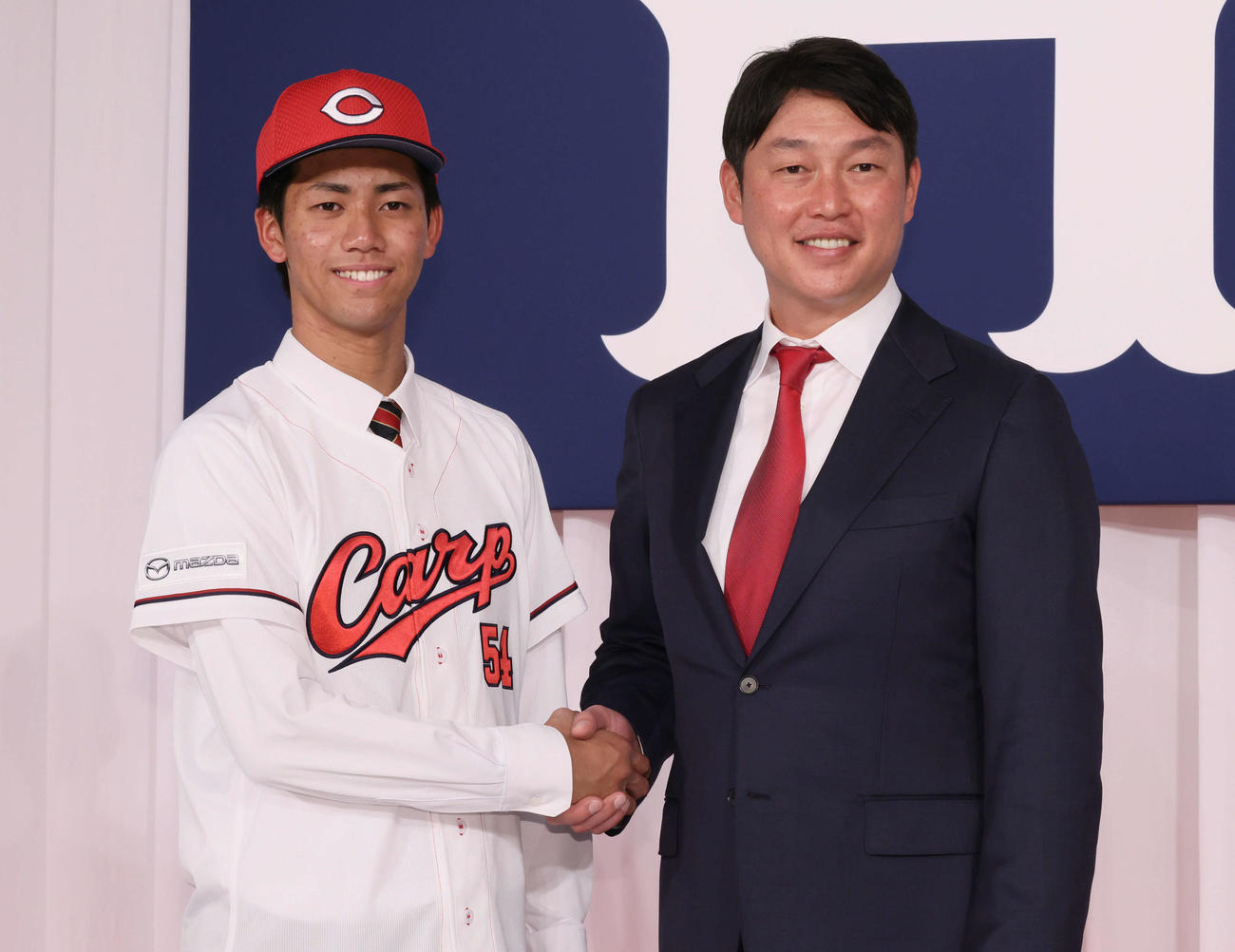 新井監督（右）と握手するドラフト6位の西川（撮影・加藤孝規）