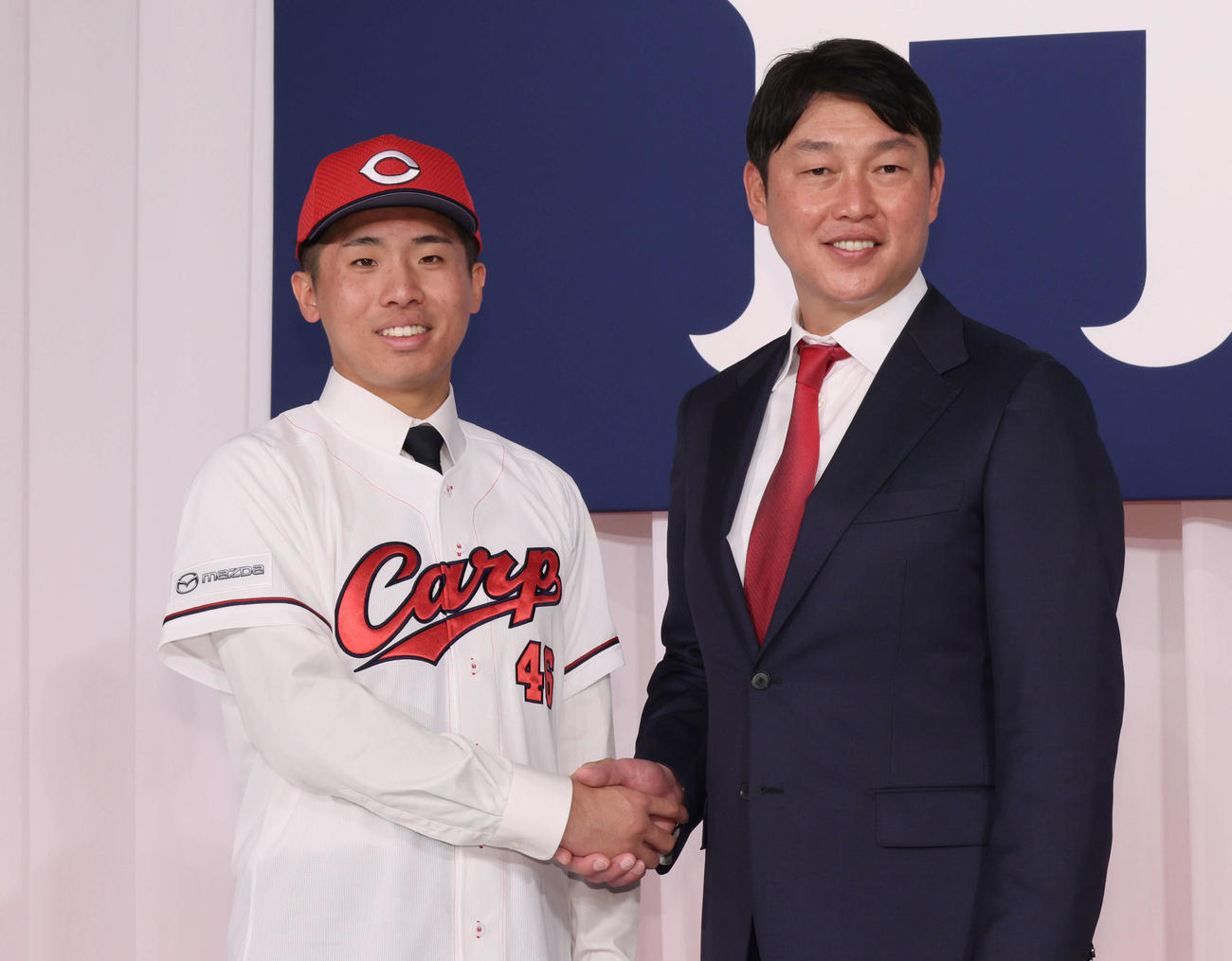 新井監督（右）と握手するドラフト7位の高木快（撮影・加藤孝規）