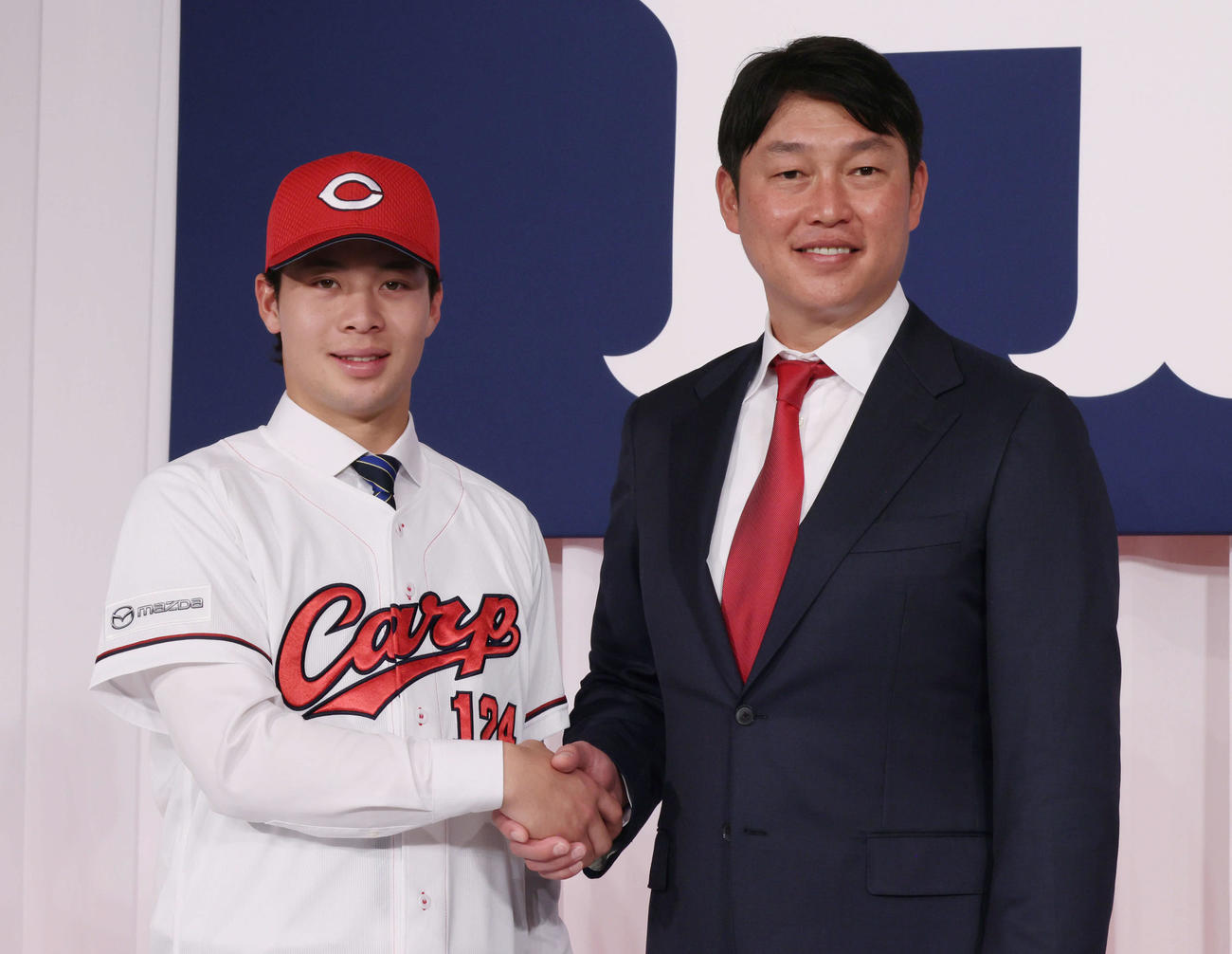 新井監督（右）と握手する育成1位の小林（撮影・加藤孝規）