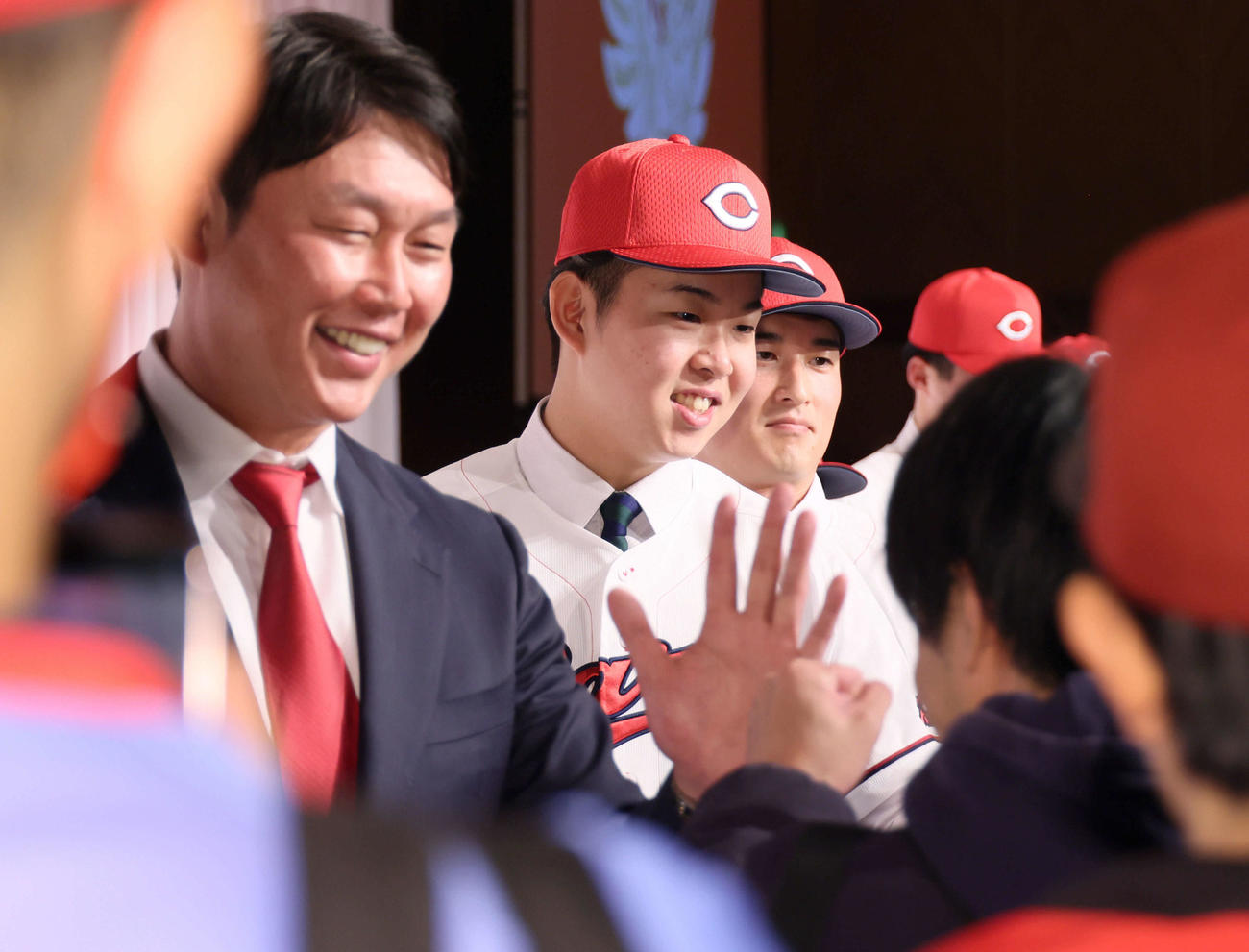 ファンとハイタッチする左から新井監督、ドラフト1位の平川、2位の斉藤汰（撮影・加藤孝規）