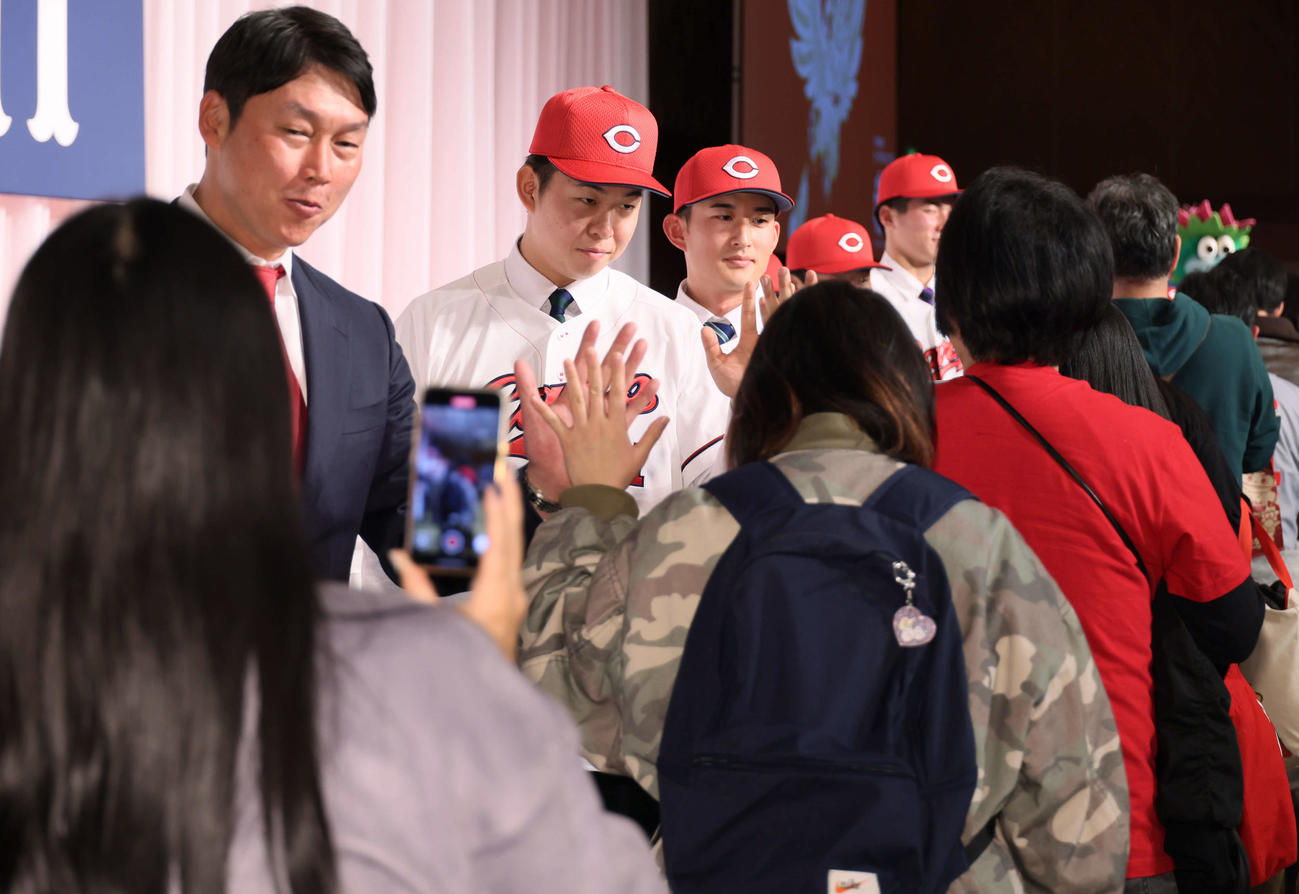 ファンとハイタッチする左から新井監督、ドラフト1位の平川、2位の斉藤汰（撮影・加藤孝規）