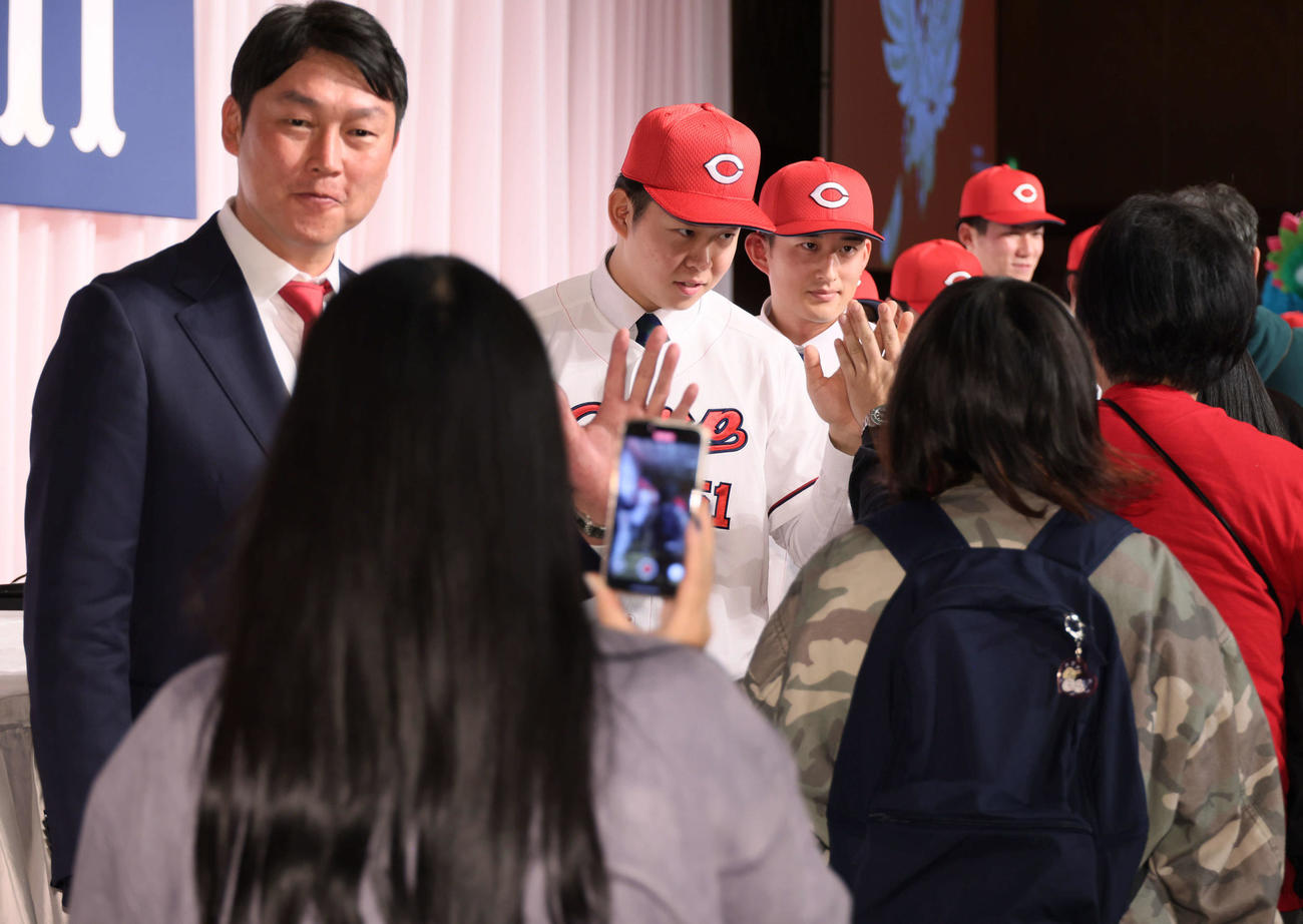 ファンとハイタッチする左から新井監督、ドラフト1位の平川、2位の斉藤汰（撮影・加藤孝規）