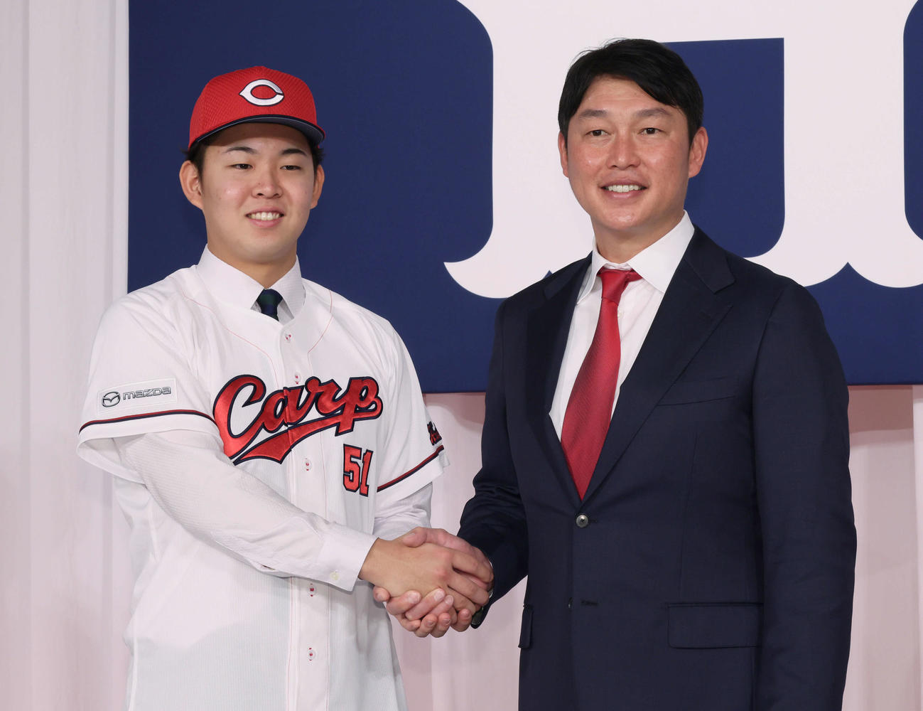 新井監督（右）と握手するドラフト1位の平川（撮影・加藤孝規）