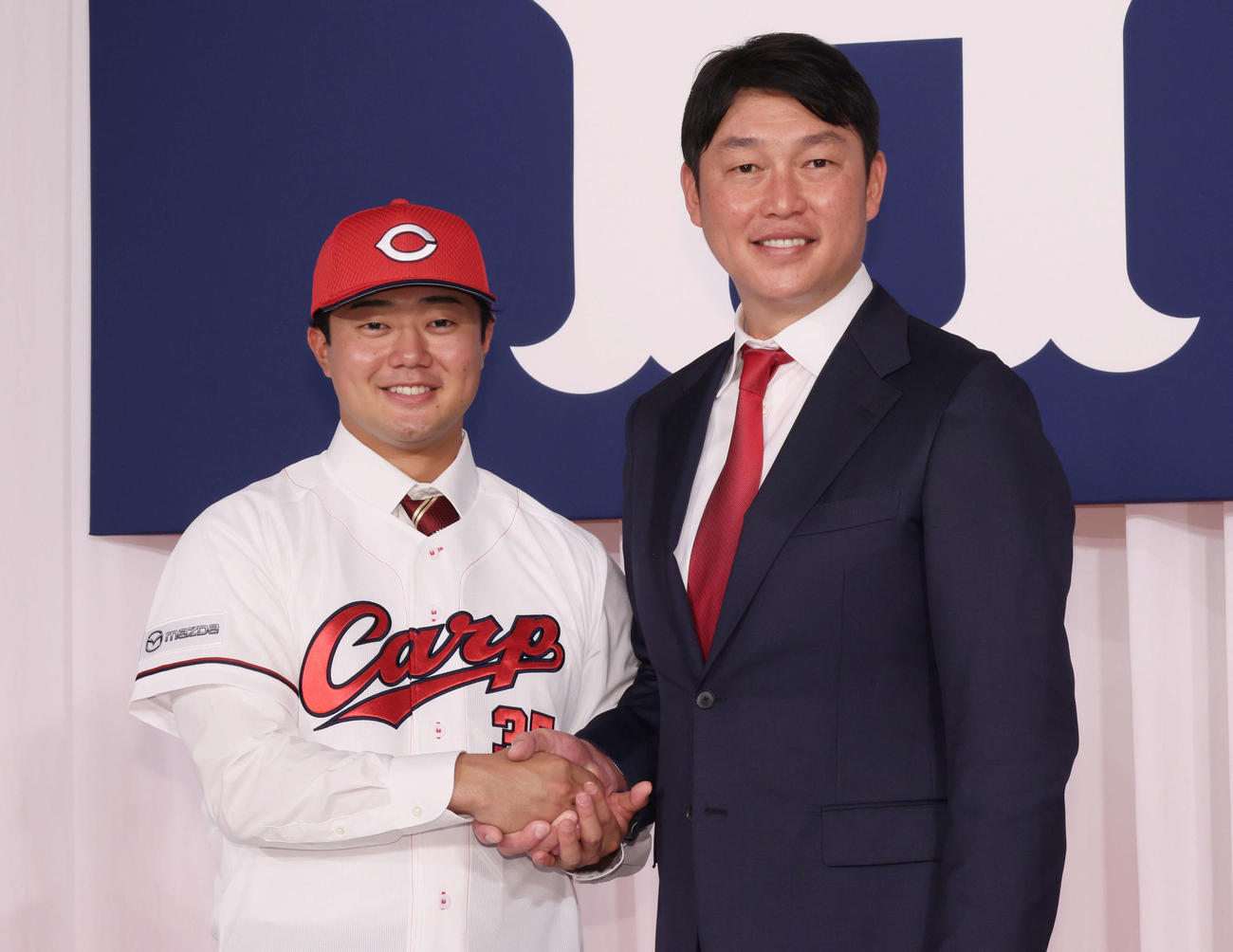 新井監督（右）と握手するドラフト4位の工藤（撮影・加藤孝規）
