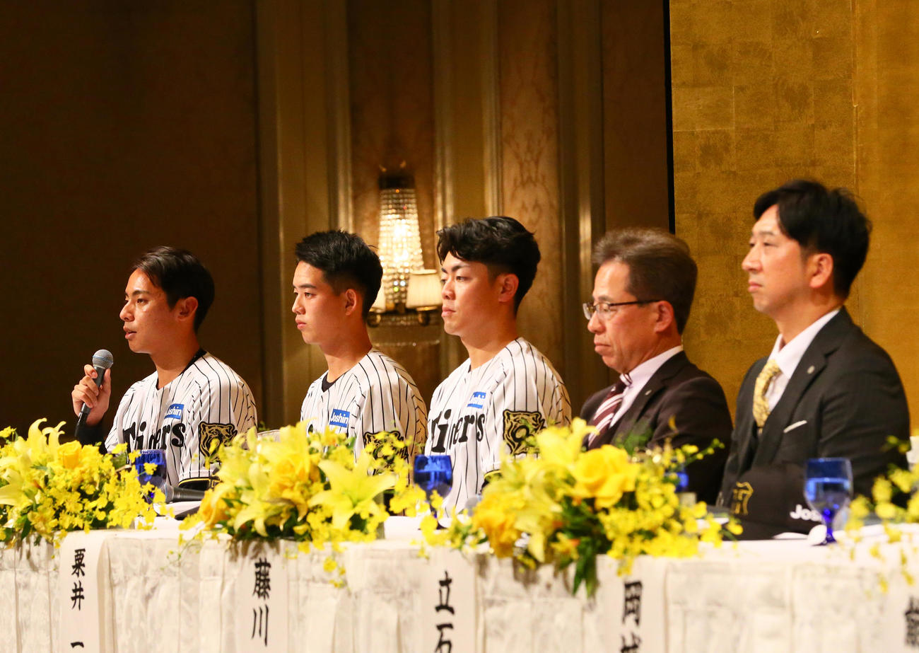 阪神新人入団会見であいさつする阪神ドラフト育成1位の神宮（左）。左2人目から早瀬、谷端、粟井社長、藤川監督（撮影・上山淳一）