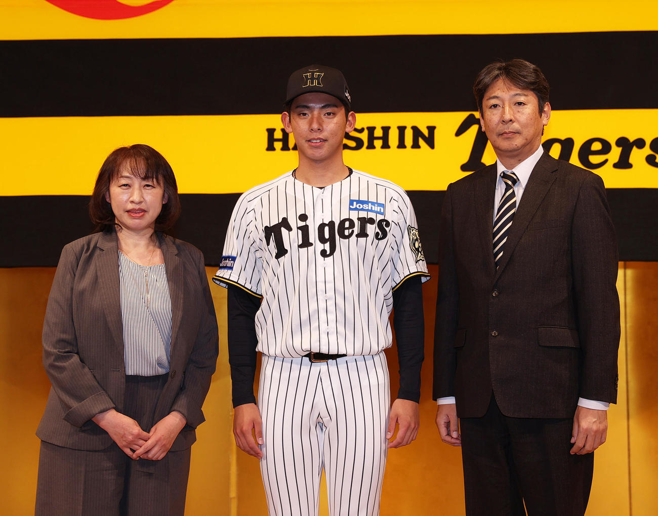 阪神の新人入団会見後、ドラフト育成1位の神宮（中央）は家族と記念写真を撮る（撮影・上山淳一）