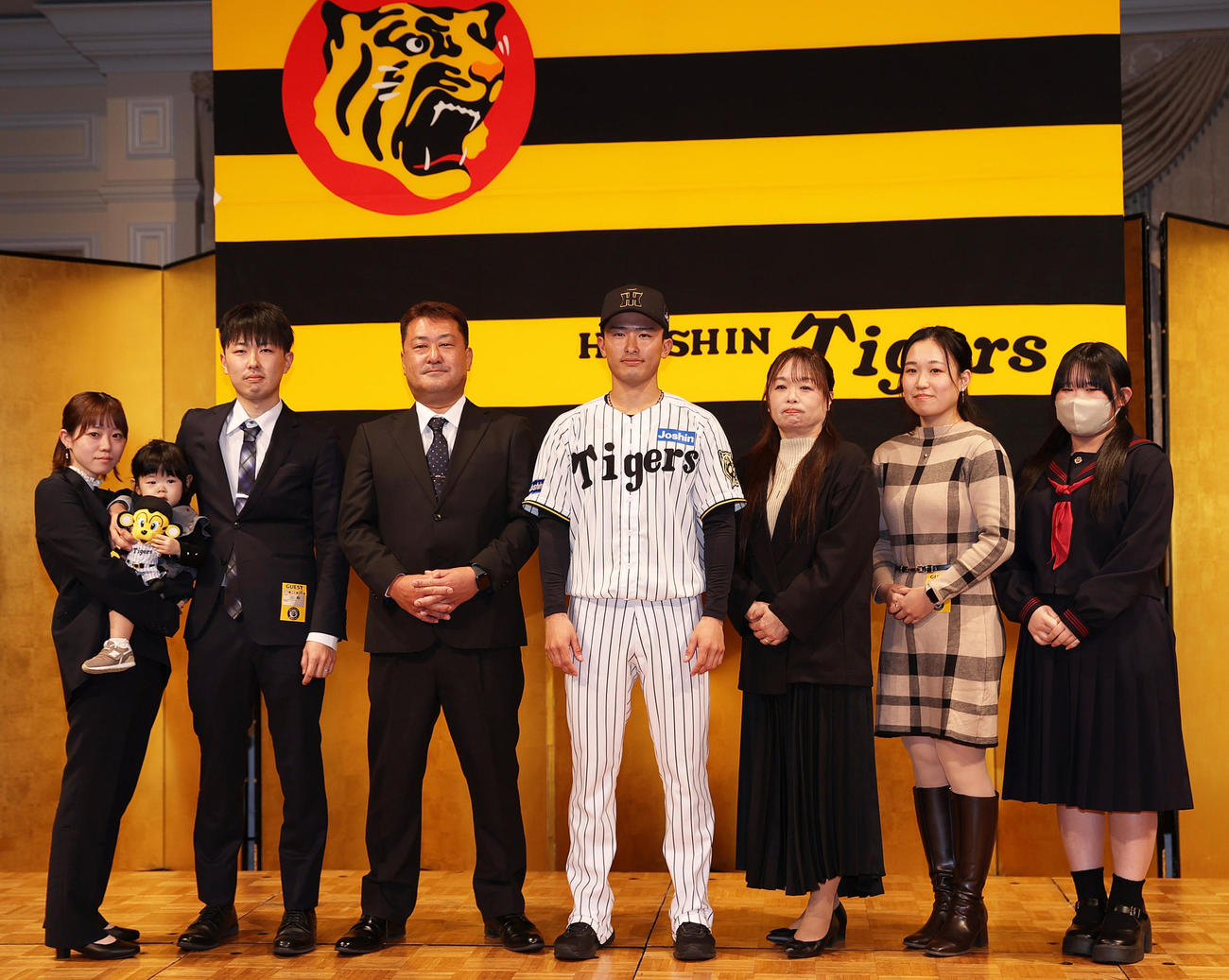 阪神の新人入団会見後、ドラフト育成2位の山崎（左から5人目）は家族と記念写真を撮る（撮影・上山淳一）