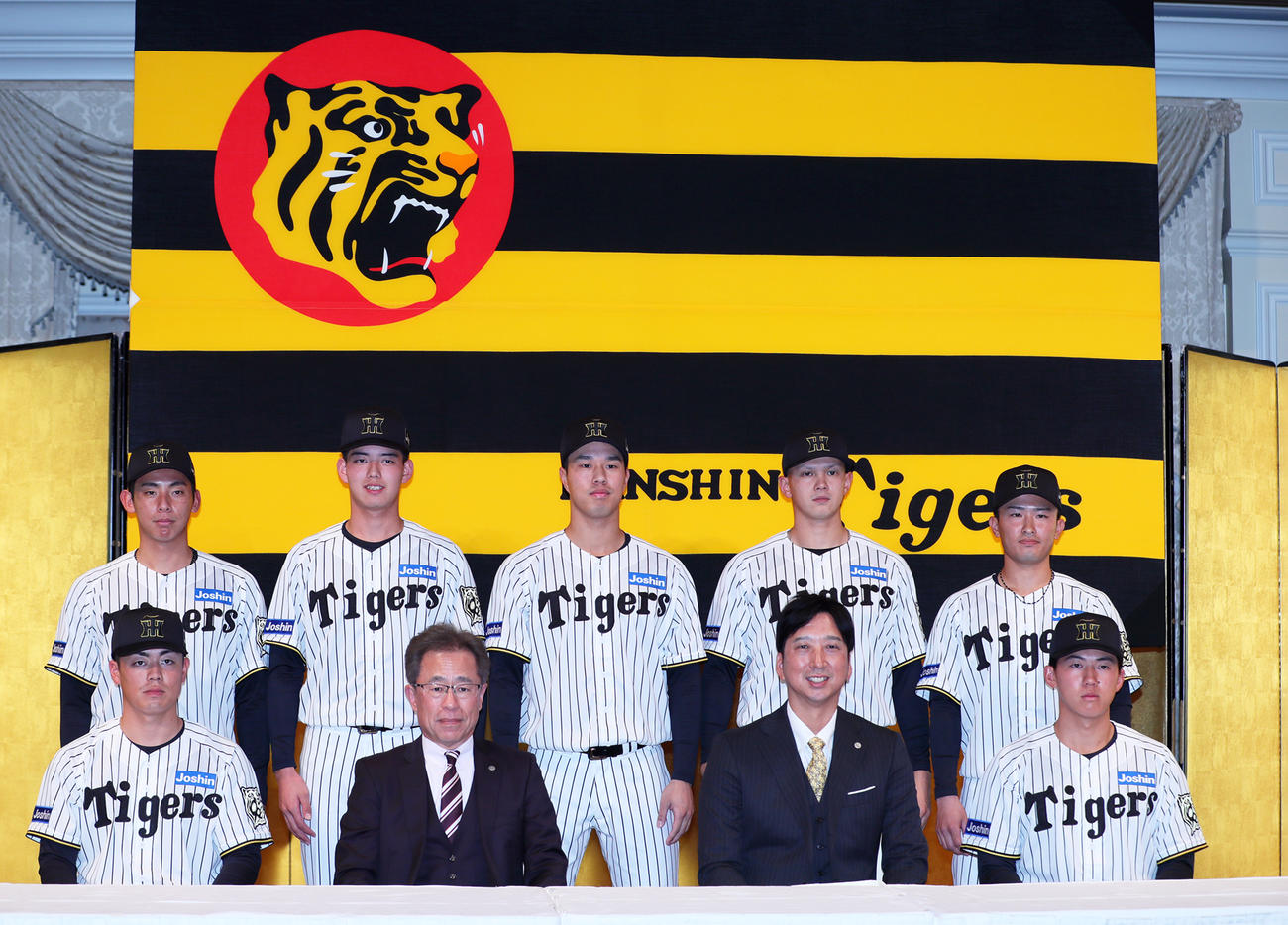 2026年度阪神新人入団発表会で記念撮影する、前列左からドラフト2位の谷端、粟井社長、藤川監督、ドラフト1位の立石、後列左からドラフト育成1位の神宮、ドラフト4位の早瀬、ドラフト3位の岡城、ドラフト5位の能登、ドラフト育成2位の山崎（撮影・上山淳一）