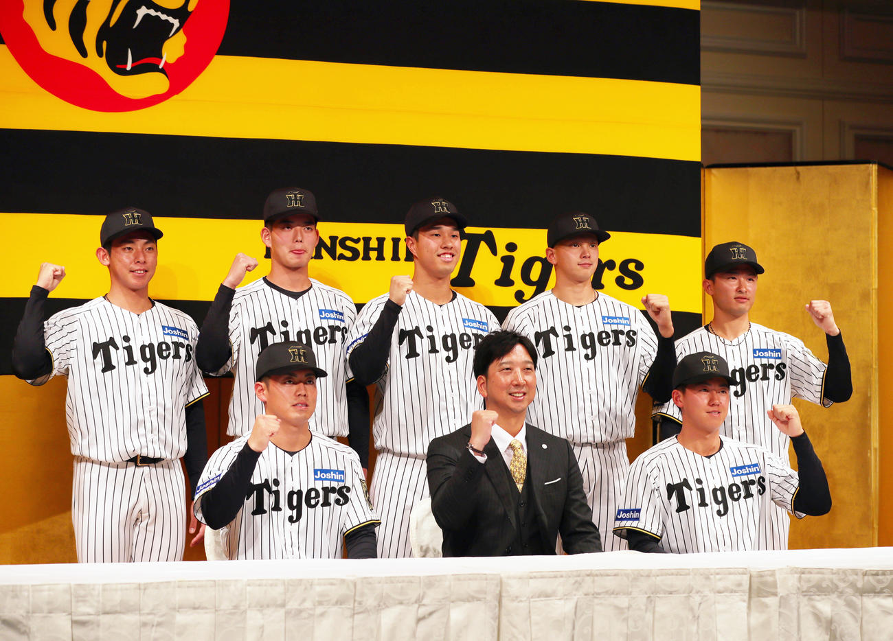 2026年度阪神新人入団発表会で記念撮影する、前列左からドラフト2位の谷端、藤川監督、ドラフト1位の立石、後列左からドラフト育成1位の神宮、ドラフト4位の早瀬、ドラフト3位の岡城、ドラフト5位の能登、ドラフト育成2位の山崎（撮影・上山淳一）