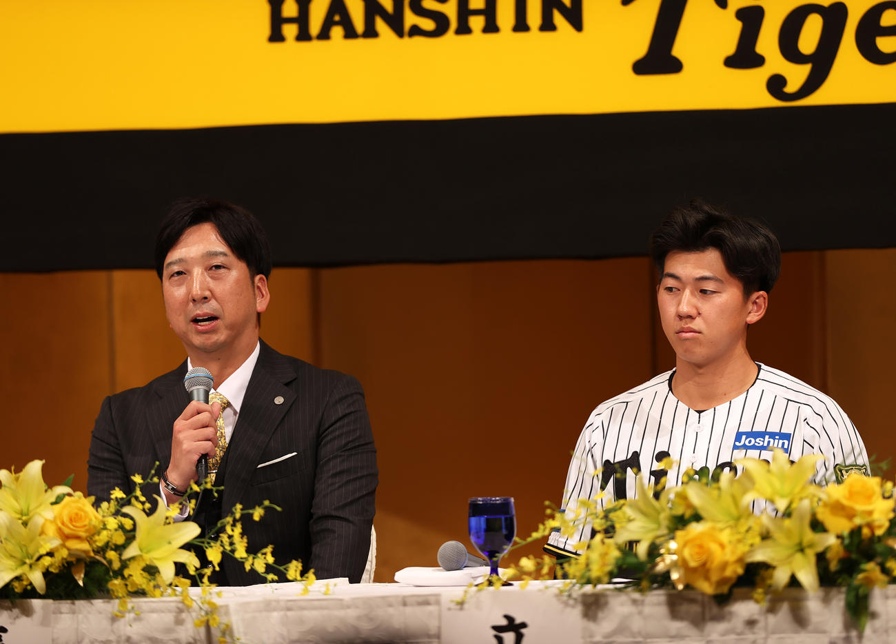 阪神新人入団会見であいさつする藤川監督。右はドラフト1位の立石（撮影・上山淳一）