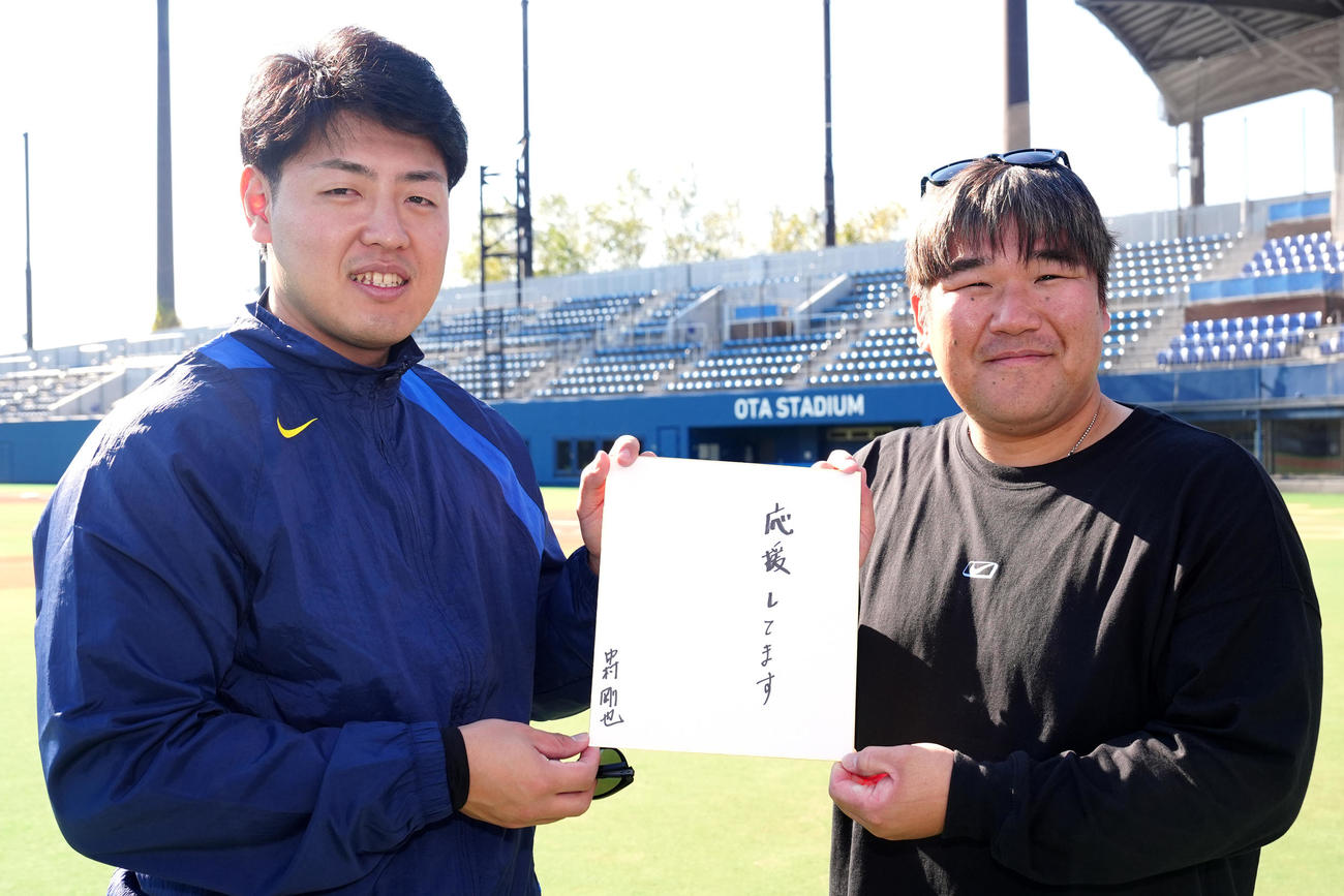 合同自主トレ後、中村（右）から「応援してます」と記された色紙を受け取る岡本（撮影・江口和貴）